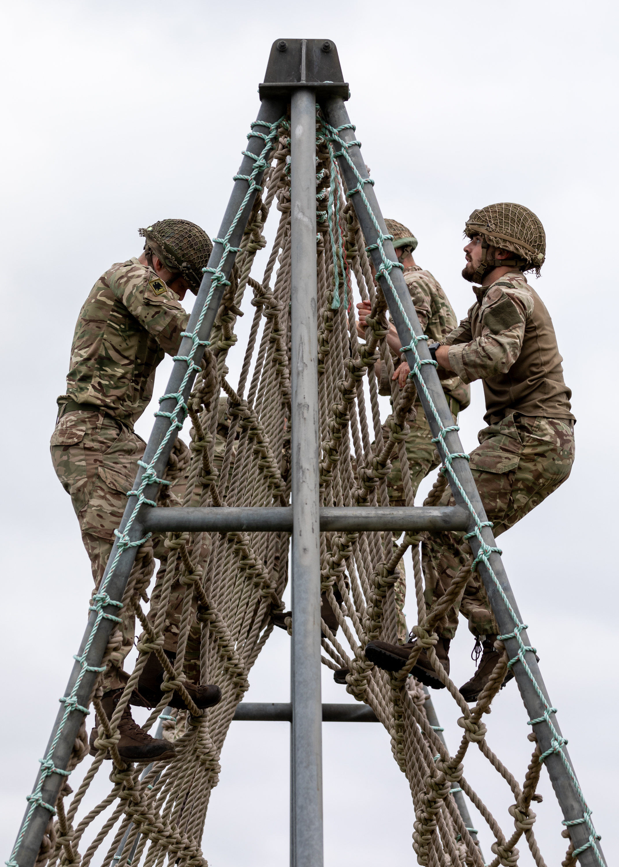 Personnel climbing a rope frame in the Assault Course.