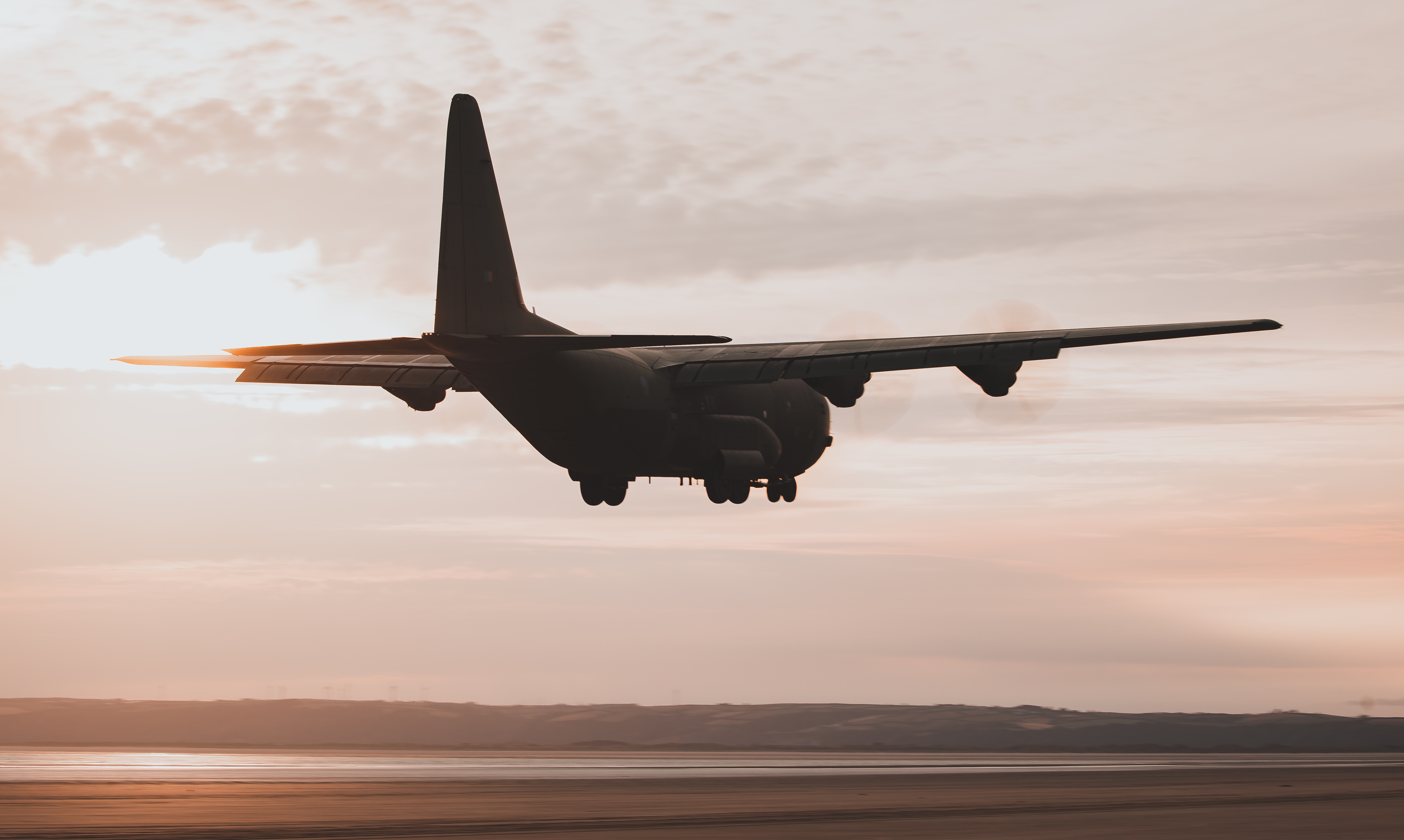 Image shows Hercules aircraft flying low.