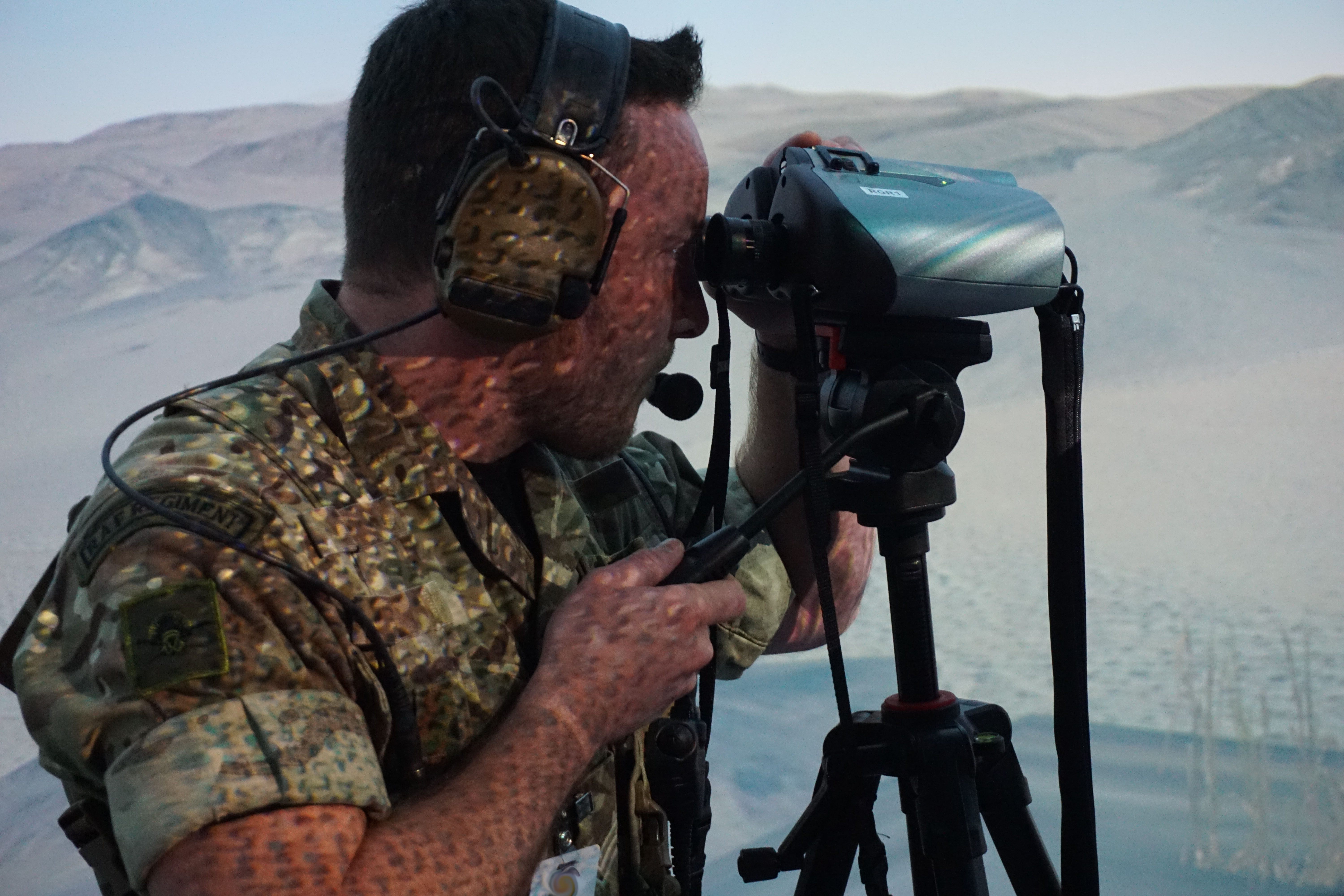 Image shows RAF aviator using binoculars and radio equipment.