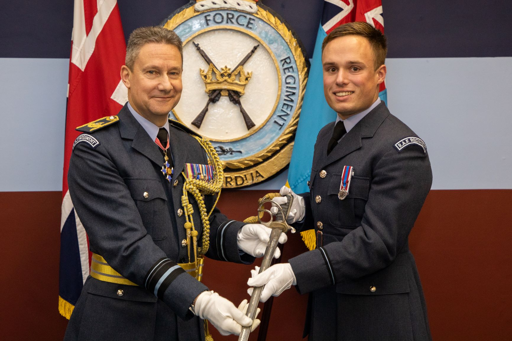 Image shows RAF aviators holding Officer's Sabre.