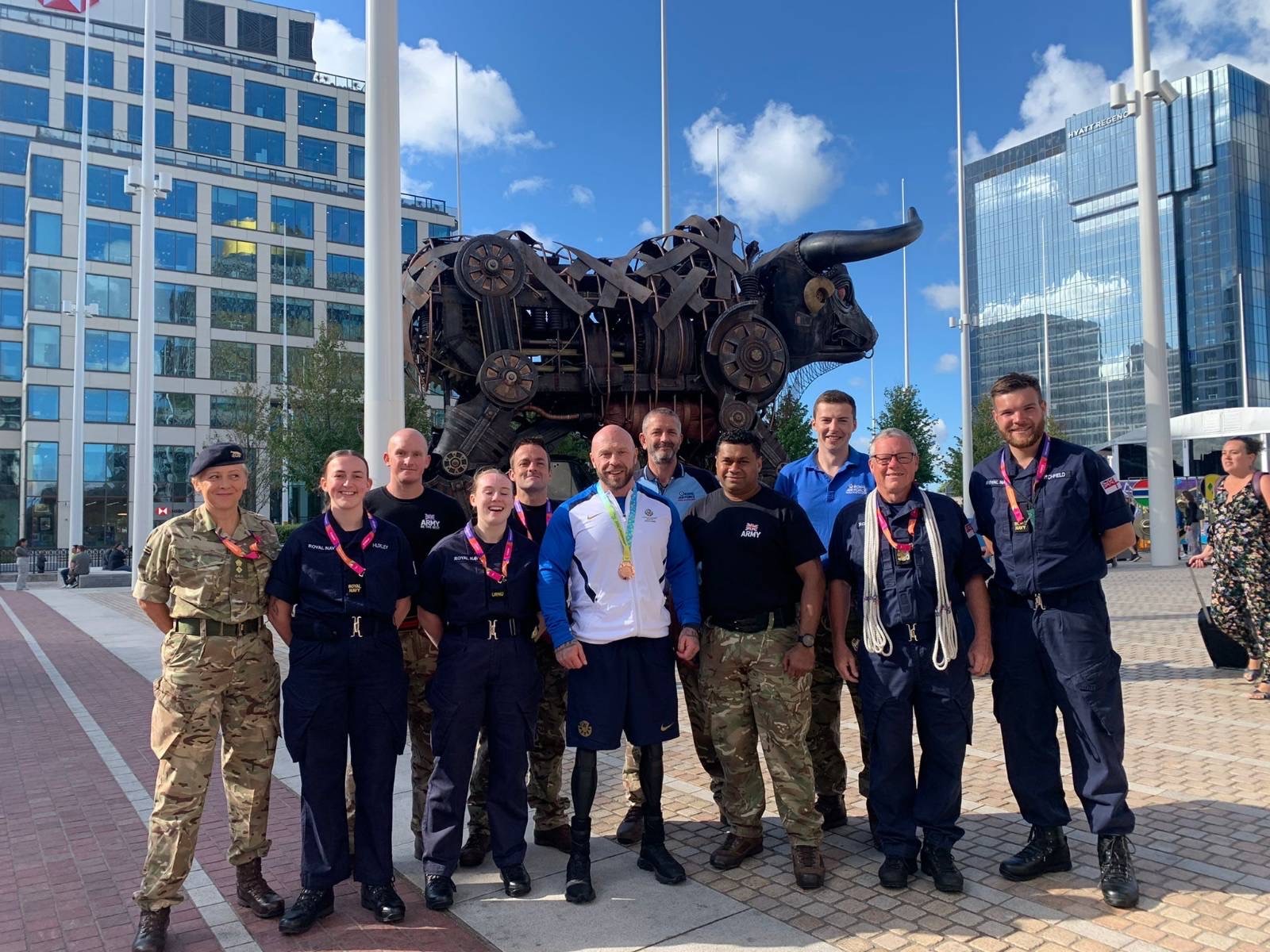 Image shows Armed Forces posing for photo by a Bull statue in Birmingham.