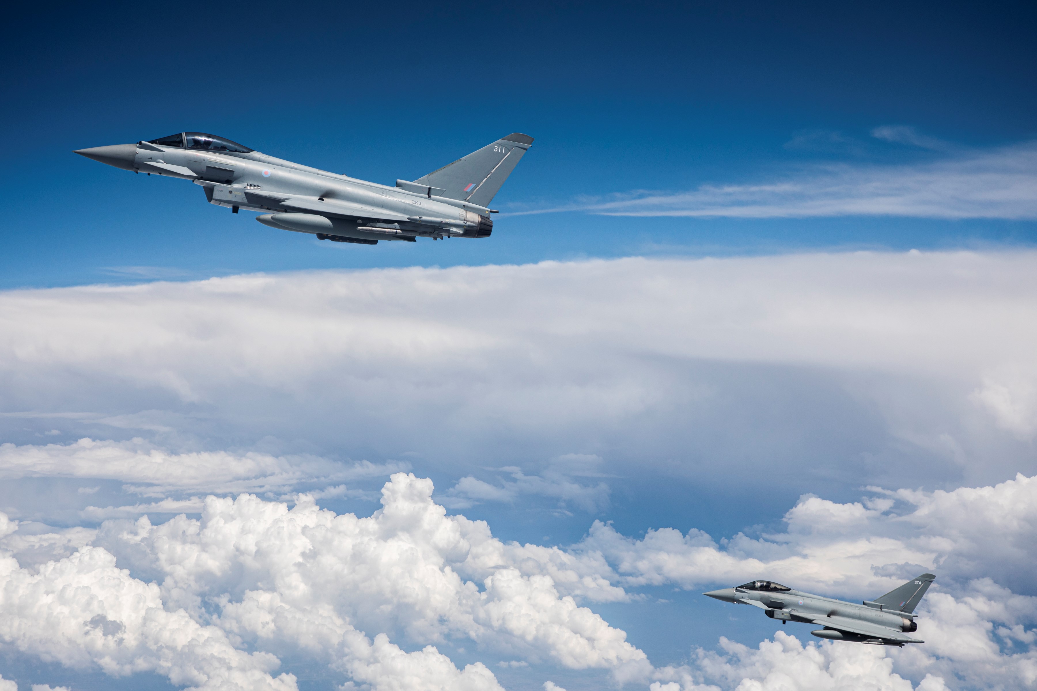 Image shows two RAF Typhoons in flight above the clouds.