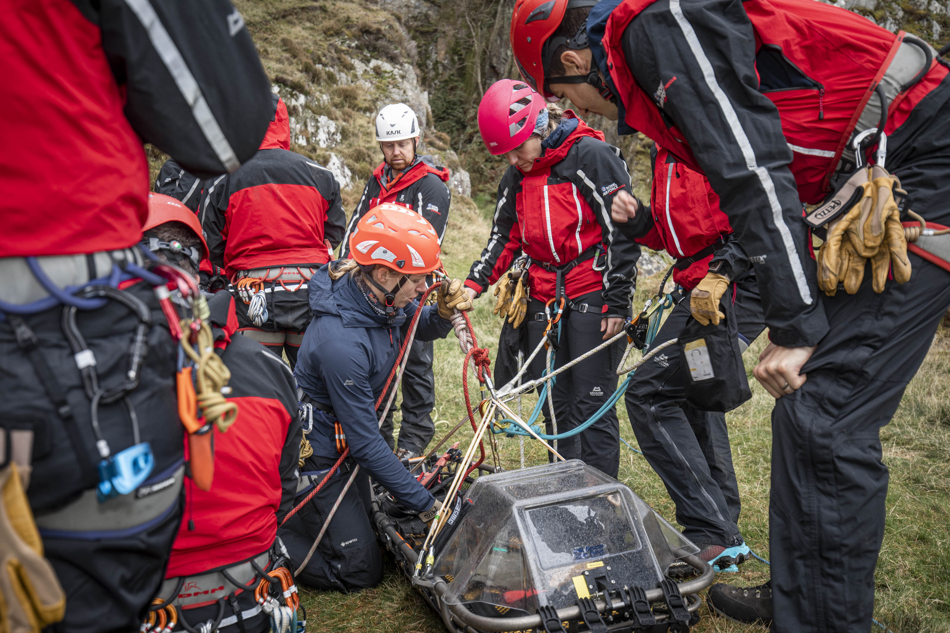 Image shows Search and Rescue team on mountain tending to patient. 