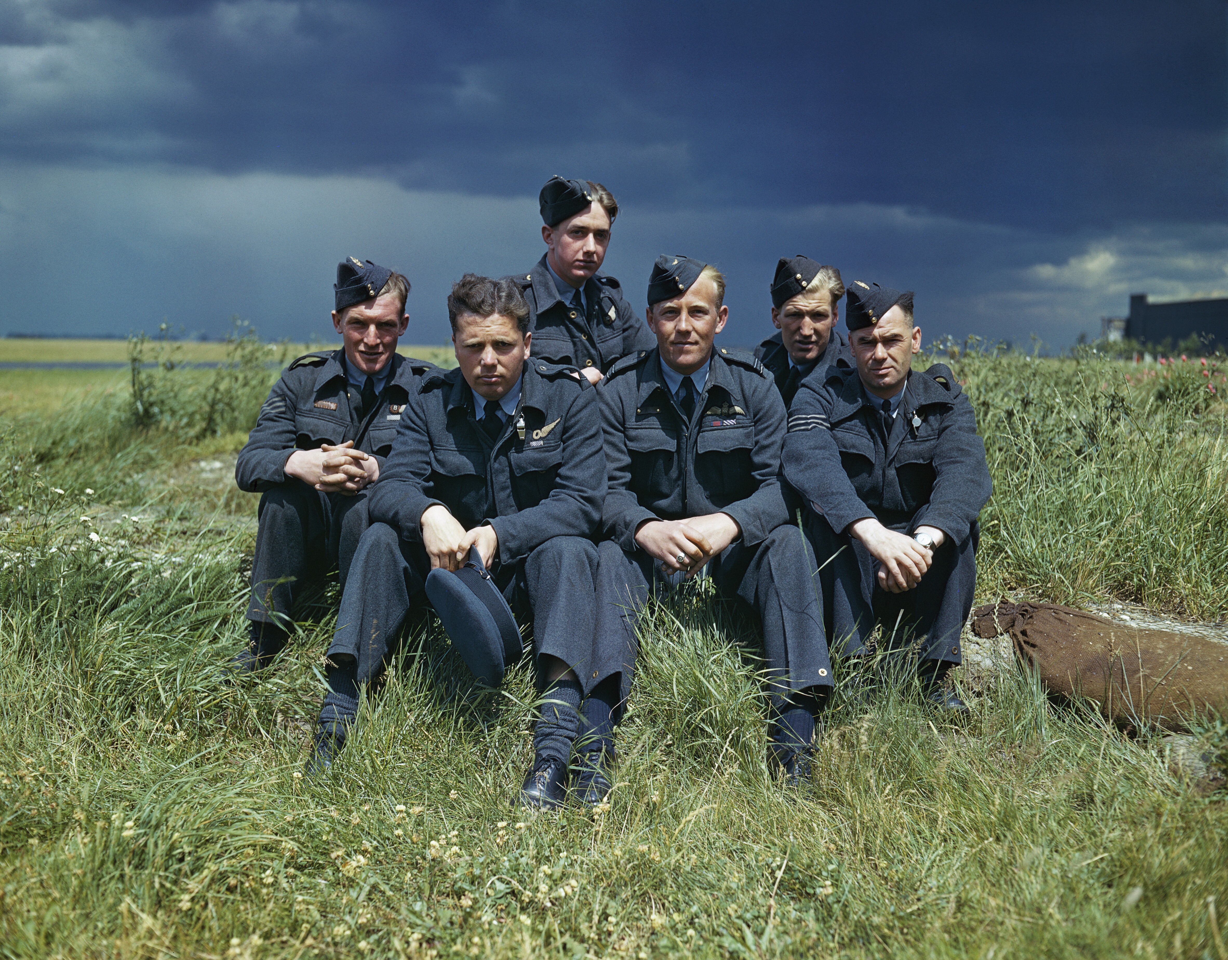 Image shows aged picture of RAF aviators sitting in field for Squadron photo.