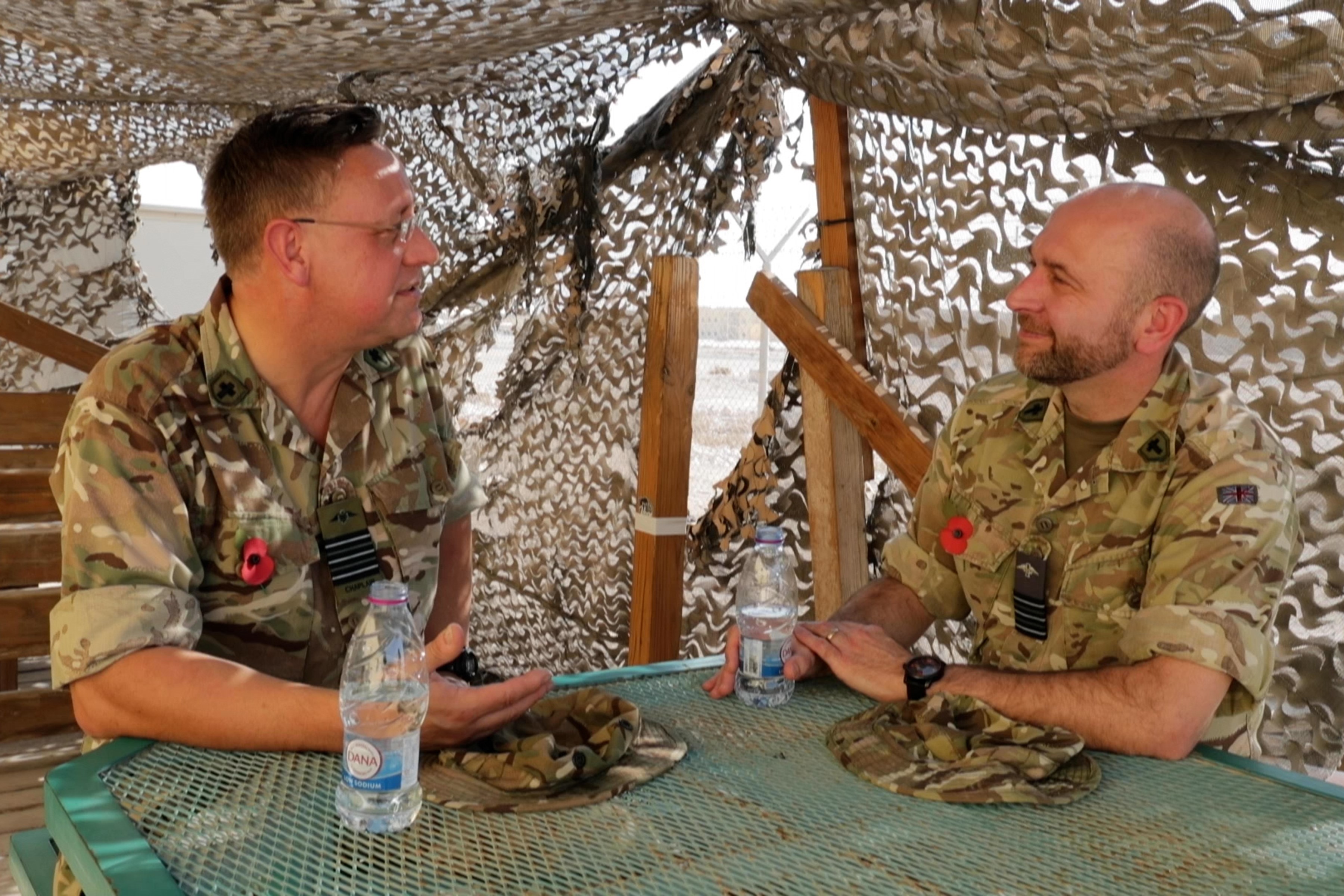 Image shows RAF aviators sitting at a table under a temporary tent structure.