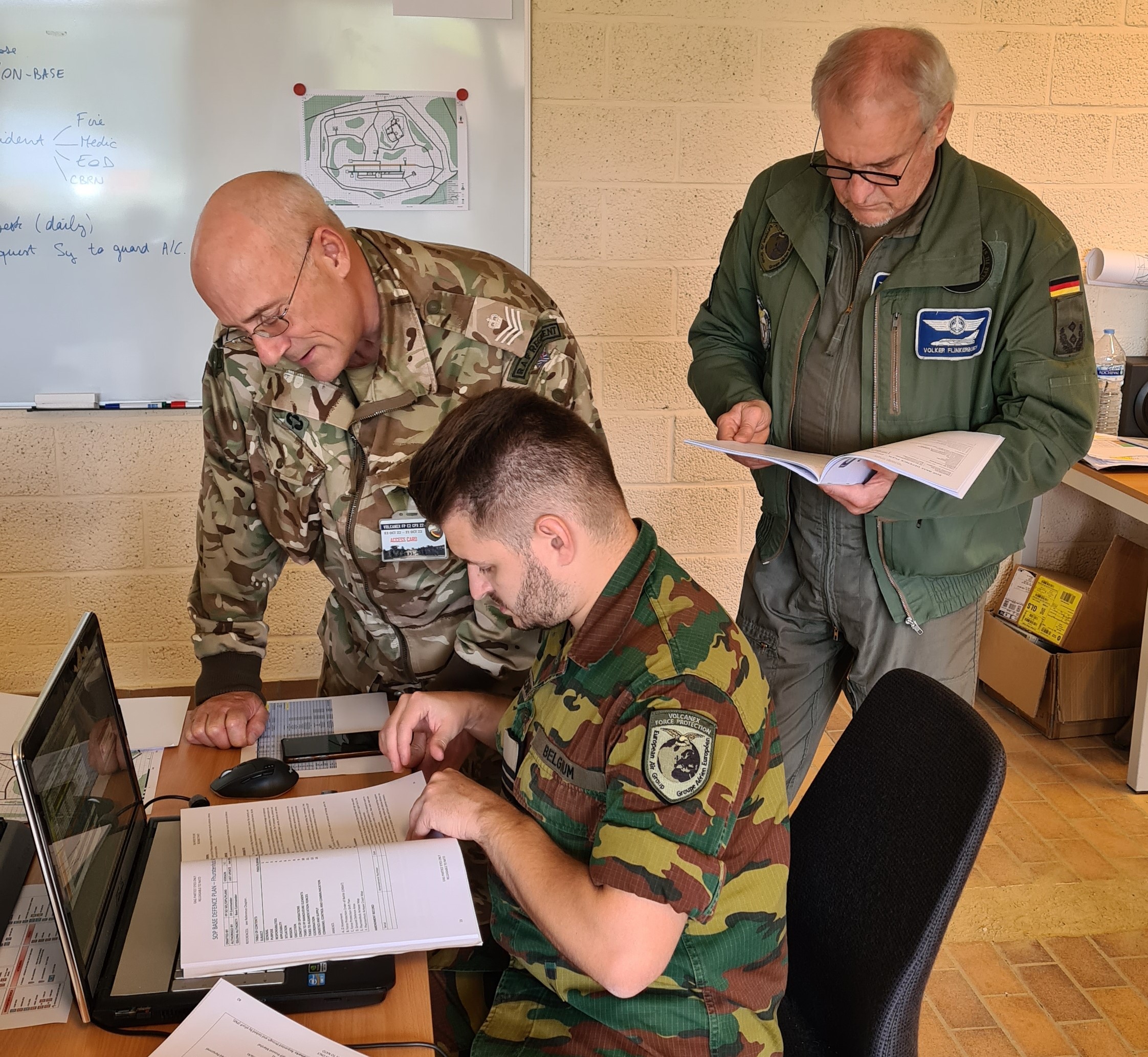 Image shows RAF personnel working at a table with computer. 