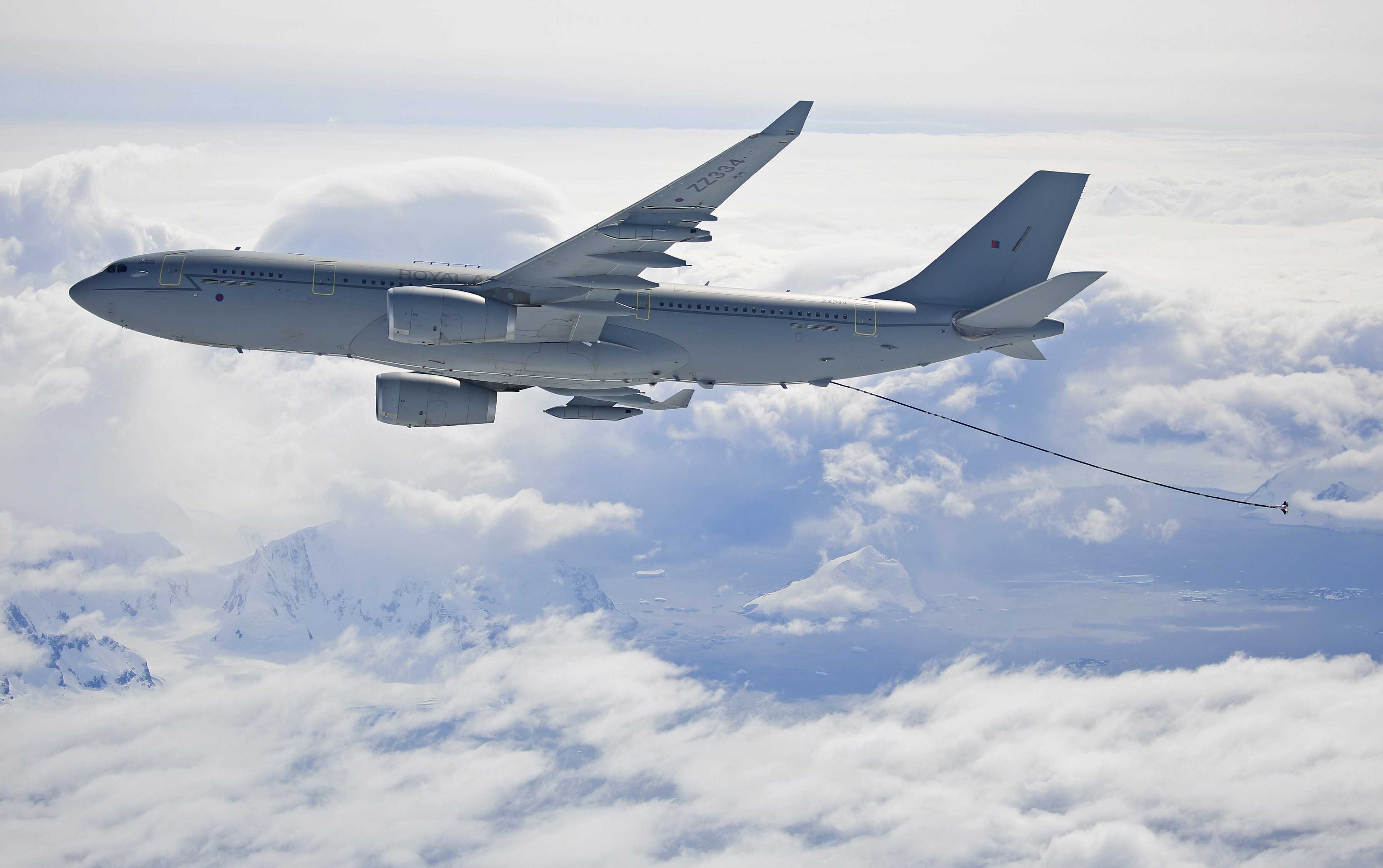 Image shows RAF carrier aircraft flying through clouds while being refuelled.