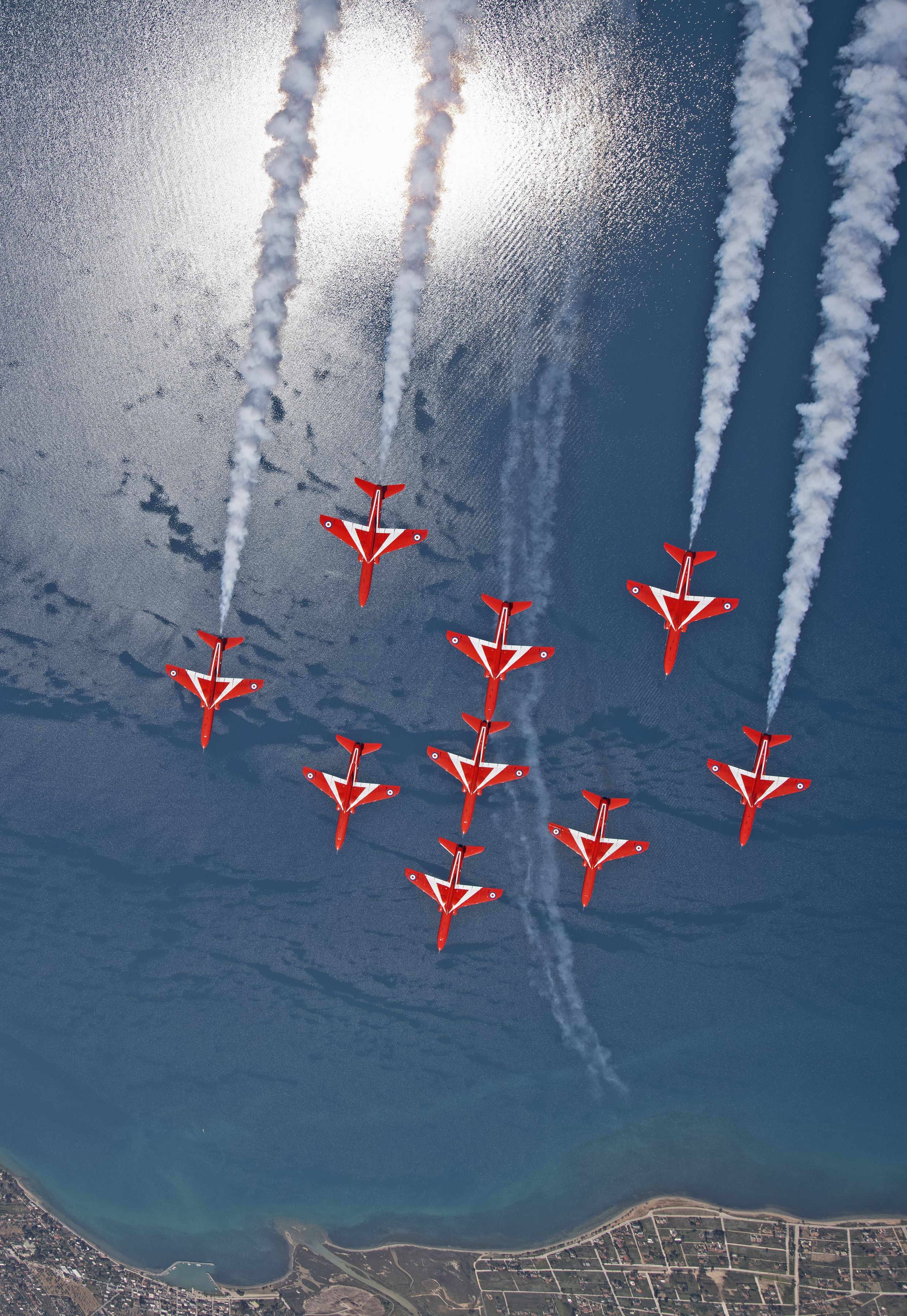 Red Arrows in formation over the water.