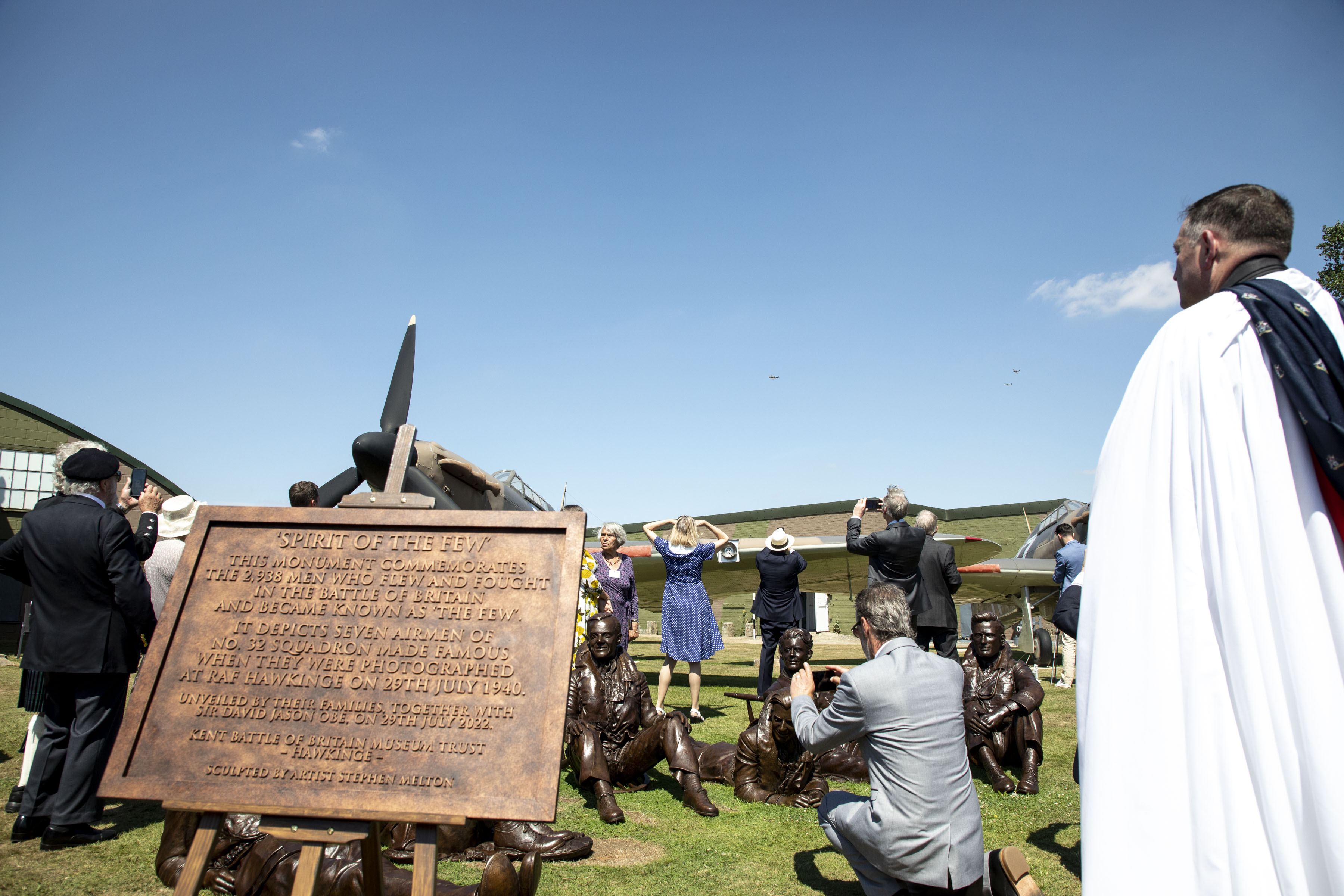 Image shows members of the public, bronze statues, RAF Padre and commemorative plaque.