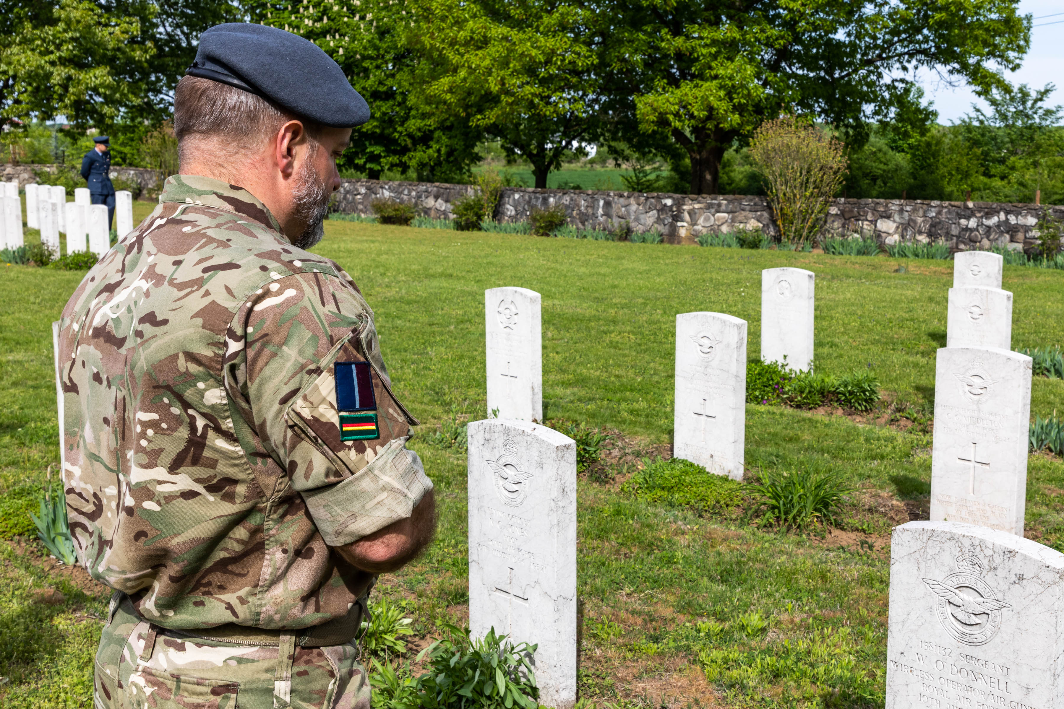 Personnel looks towards cemetery headstones.