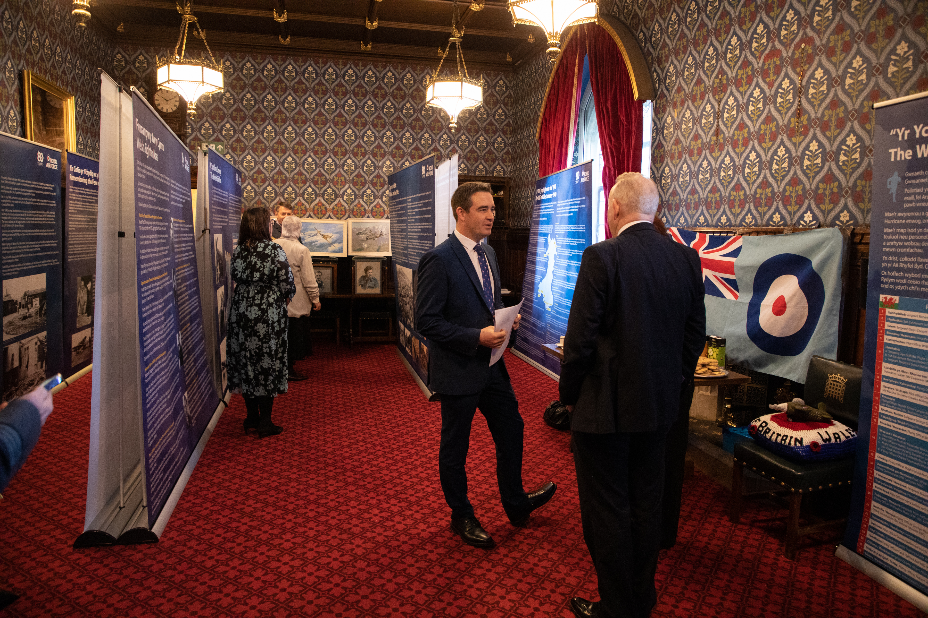 Image shows RAF aviator and civilians at exhibition.