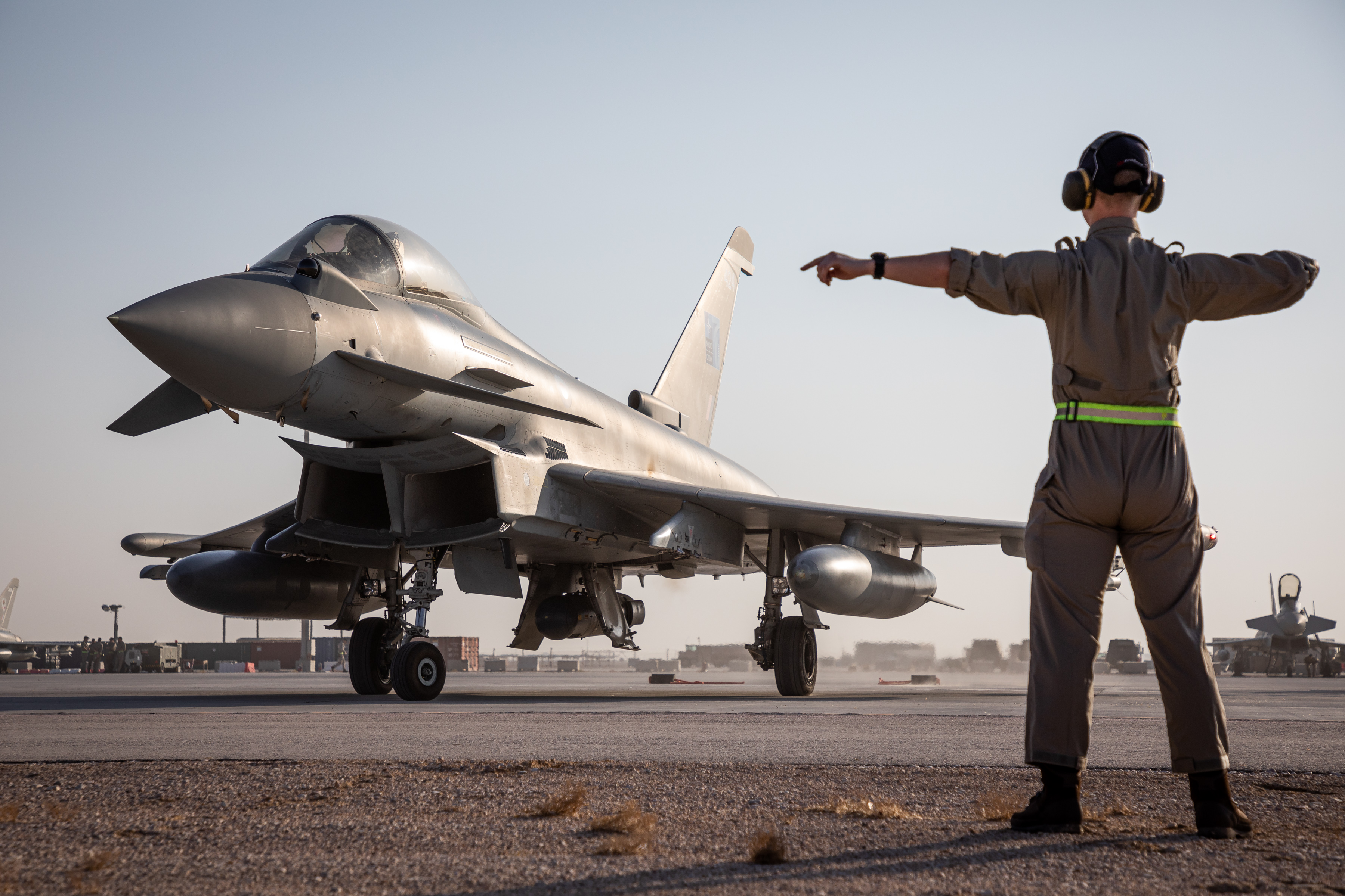 Personnel directs Typhoon on the runway.