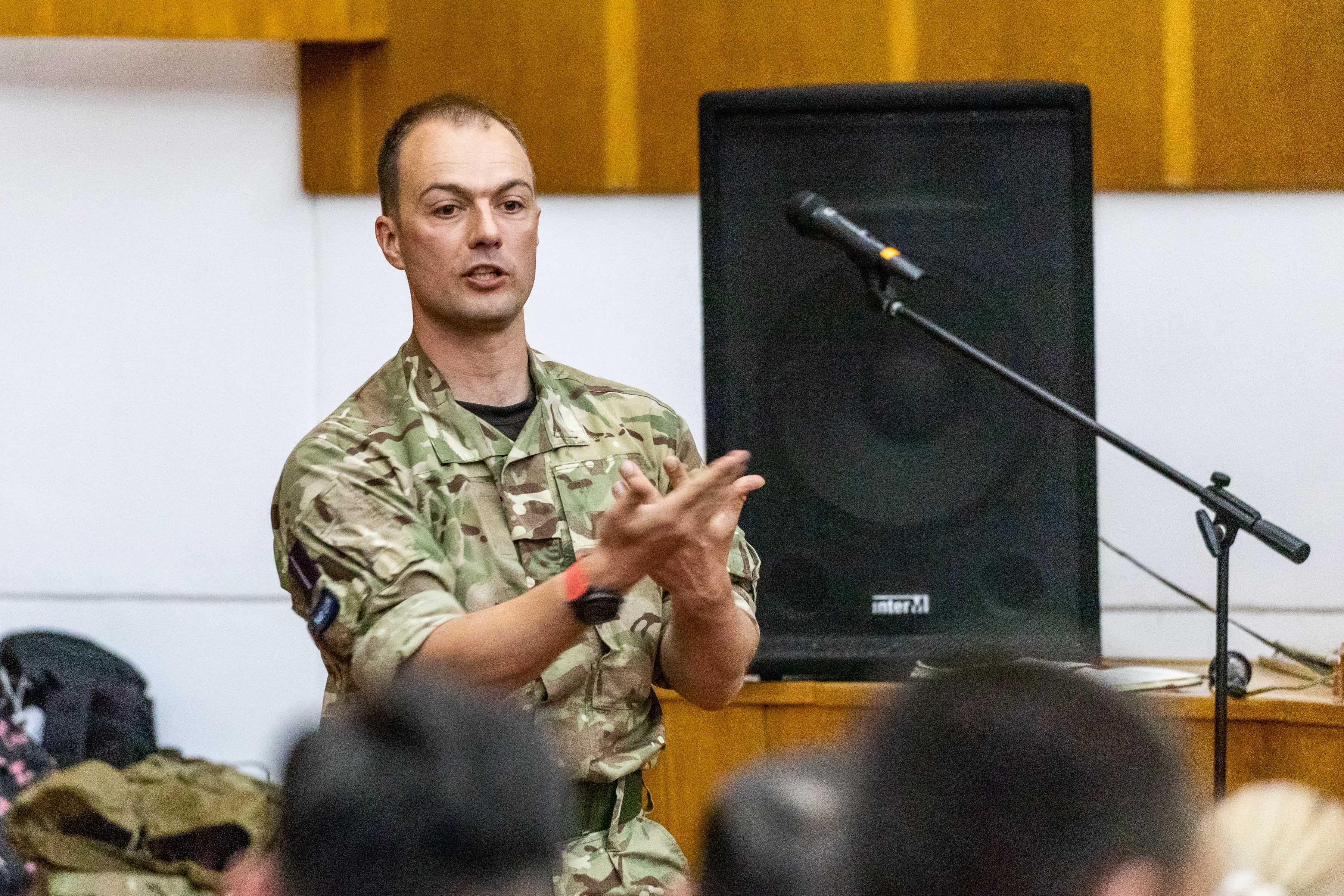 Personnel gives presentation, with microphone and speaker equipment.
