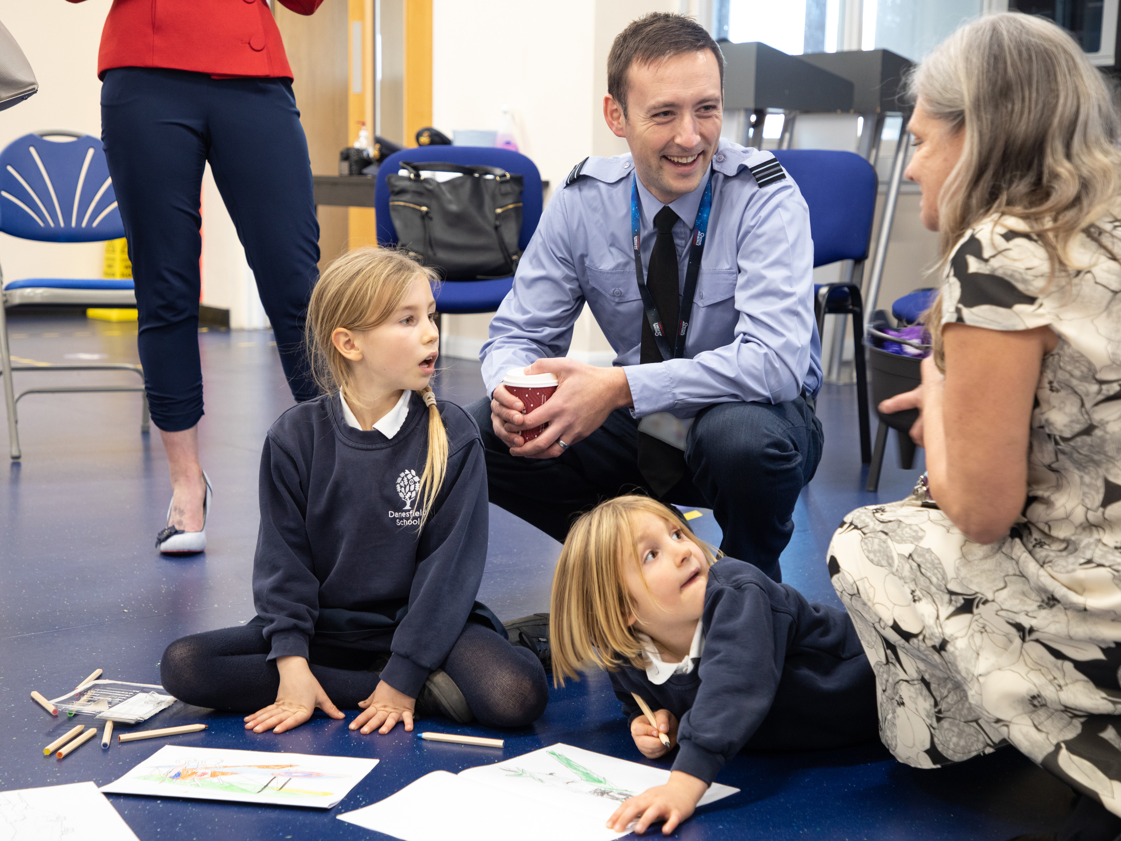 Image shows RAF aviator with school children and civilians.