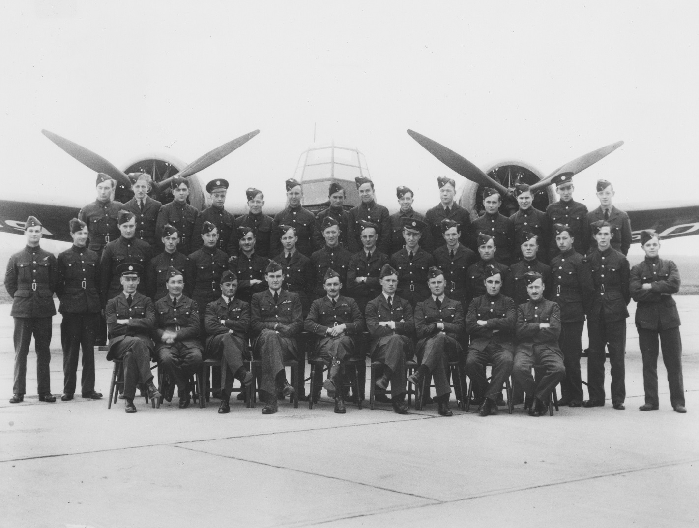 Black and white image shows RAF squadron group photo in front of an aircraft.