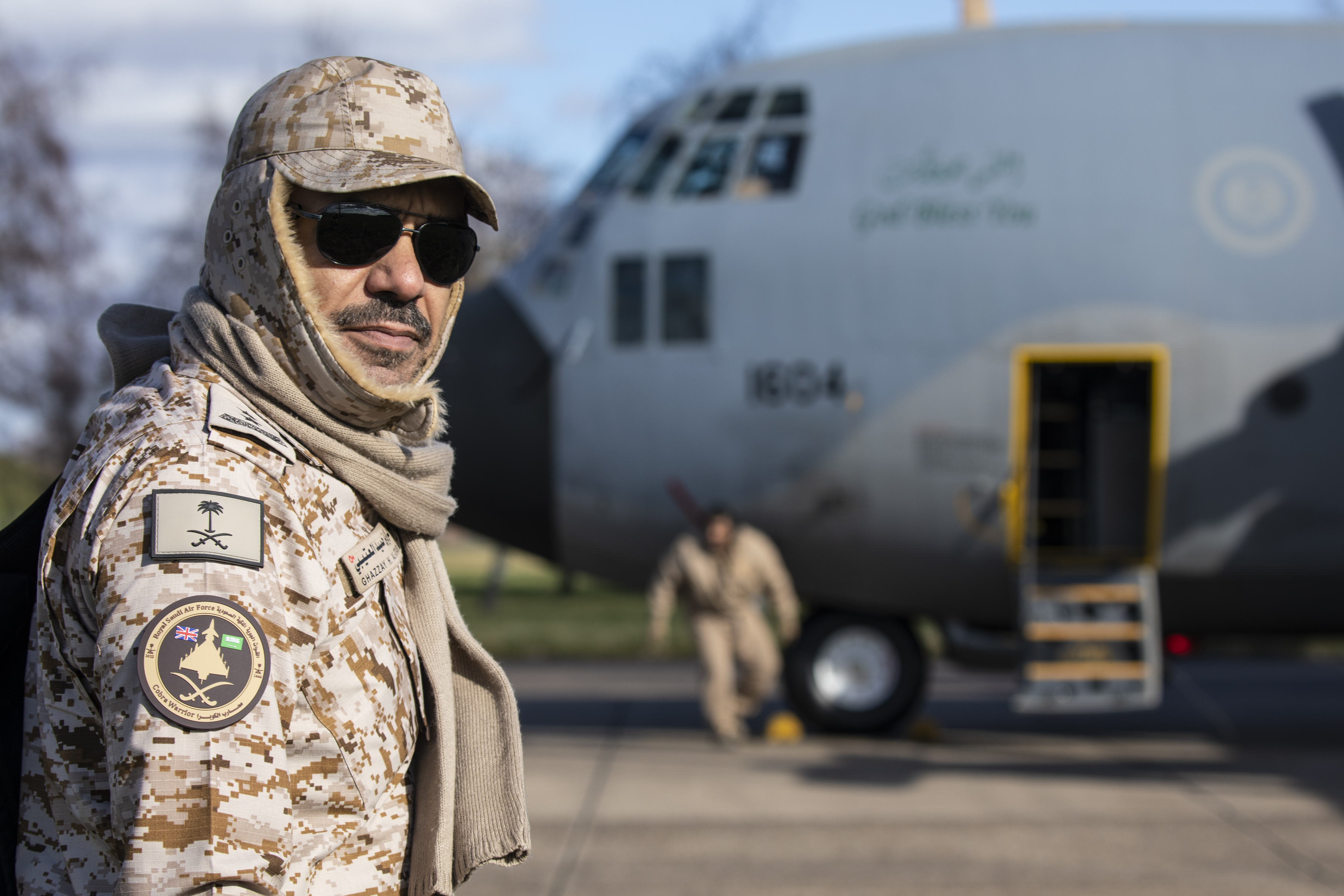 Image shows Joint RAF Qatari personnel on the airfield, with the RAF Voyager in the background.