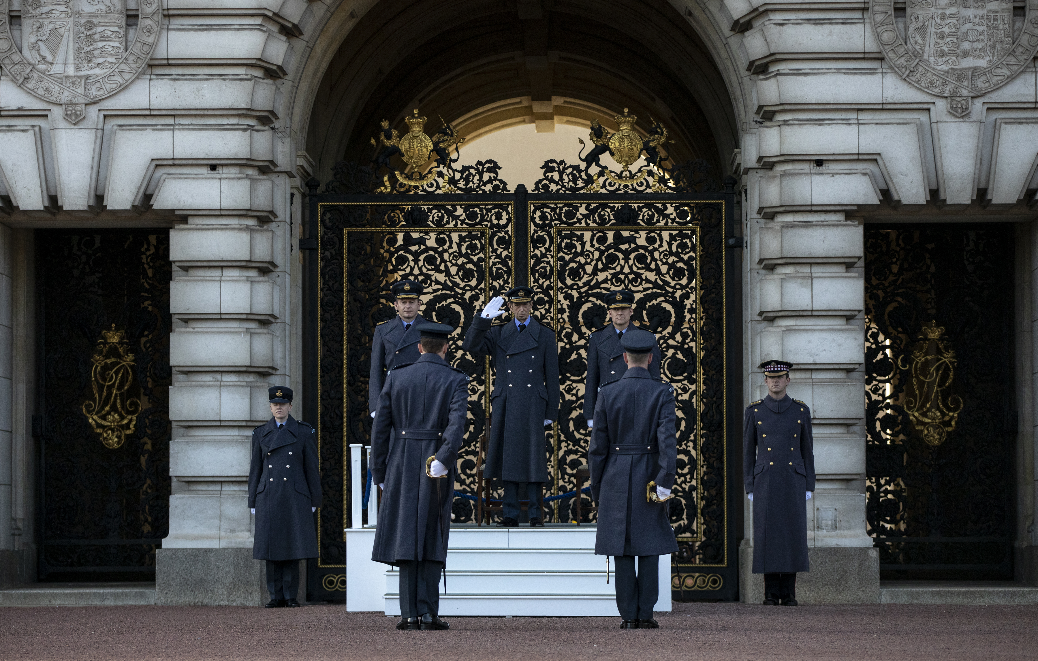 Personnel salute on parade outside Buckingham Palace.