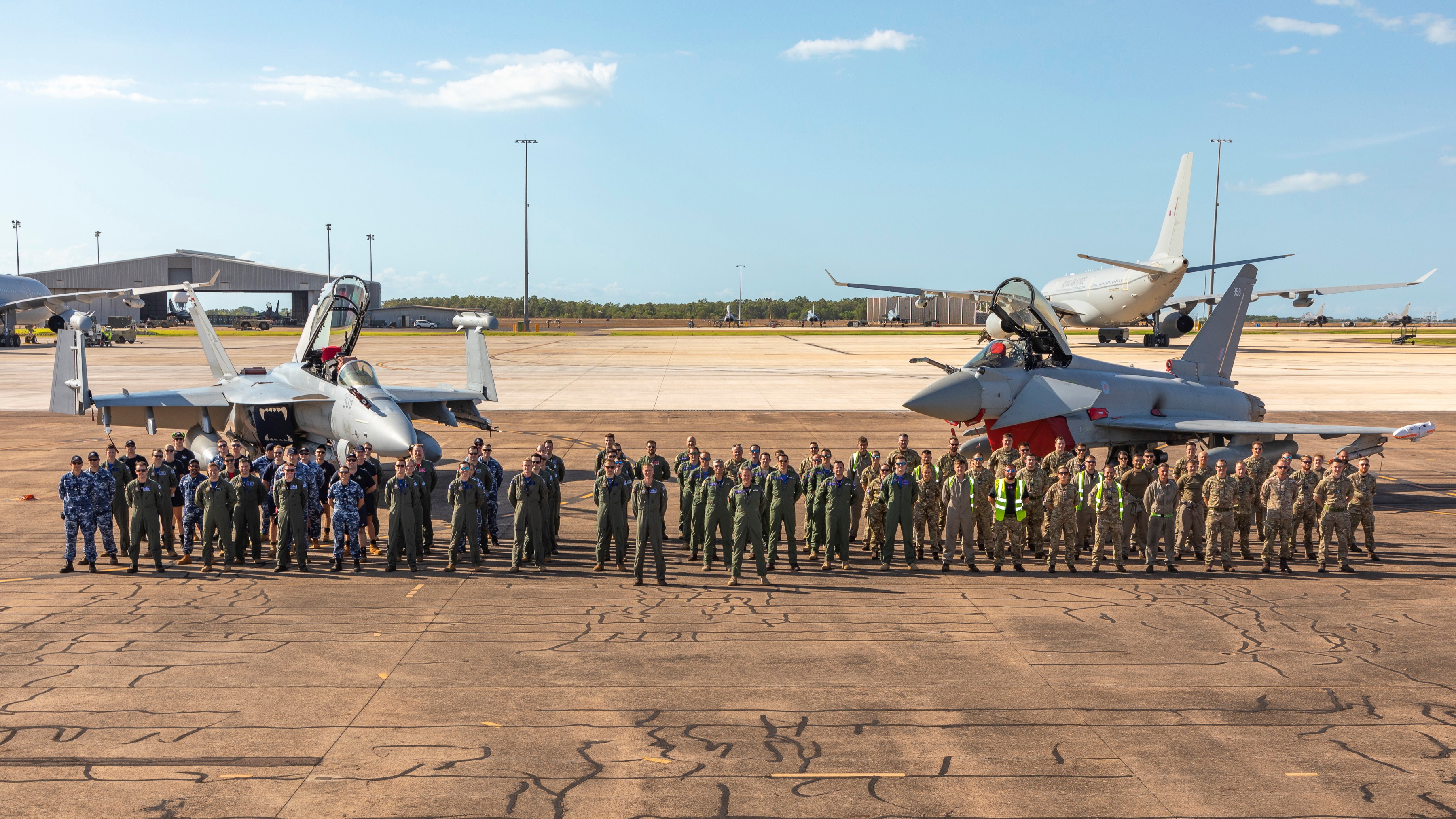 Image of a RAF Squadron in group photo on the airfield, with two Typhoons.