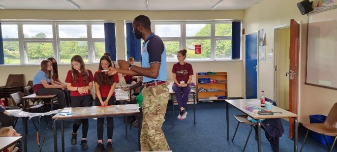 Image shows RAF STEM Ambassador presenting to school pupils in classroom.