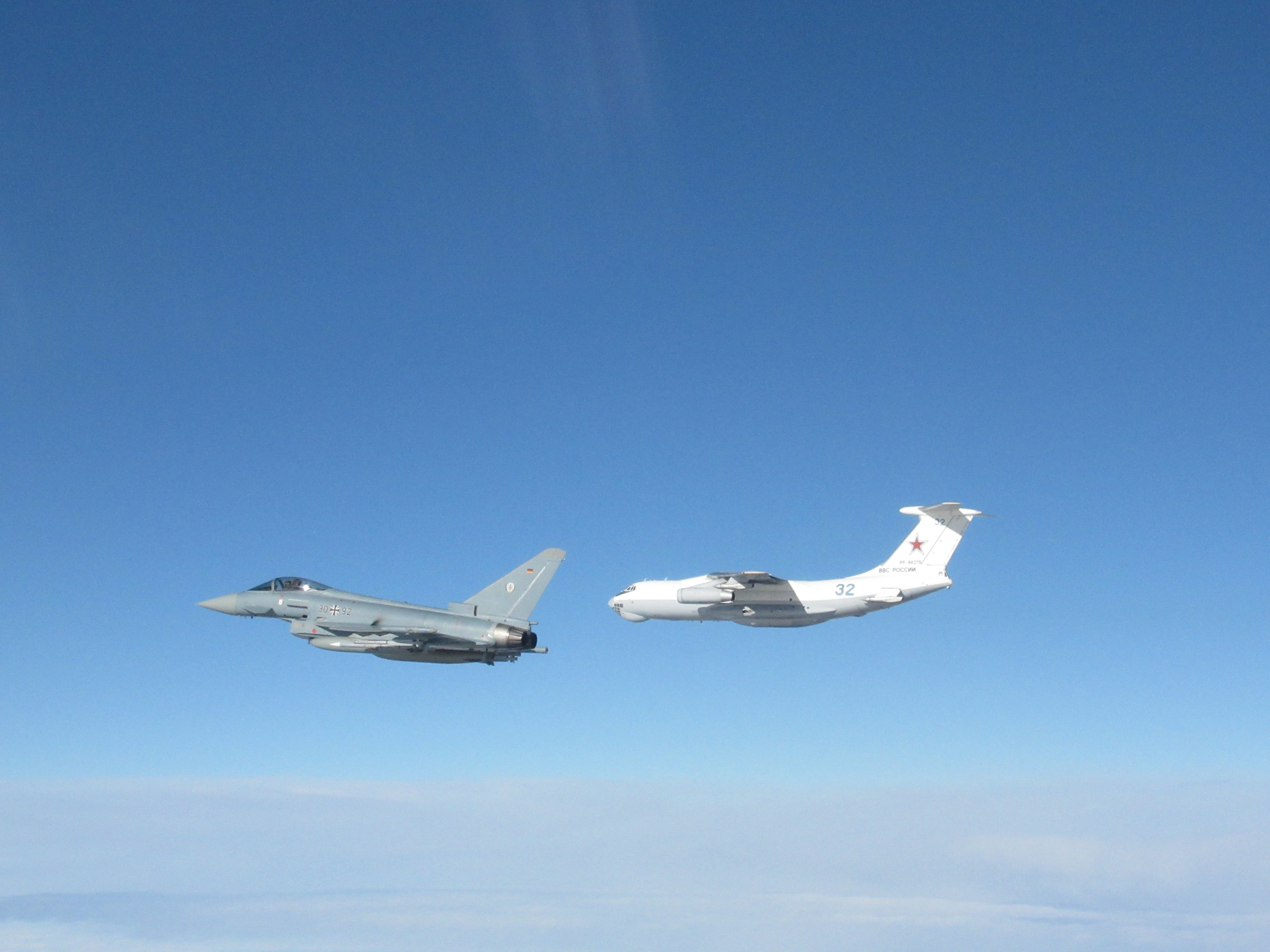 Images shows RAF Typhoon and Russian Ilyushin Il-78 Midas aircraft in flight above clouds.