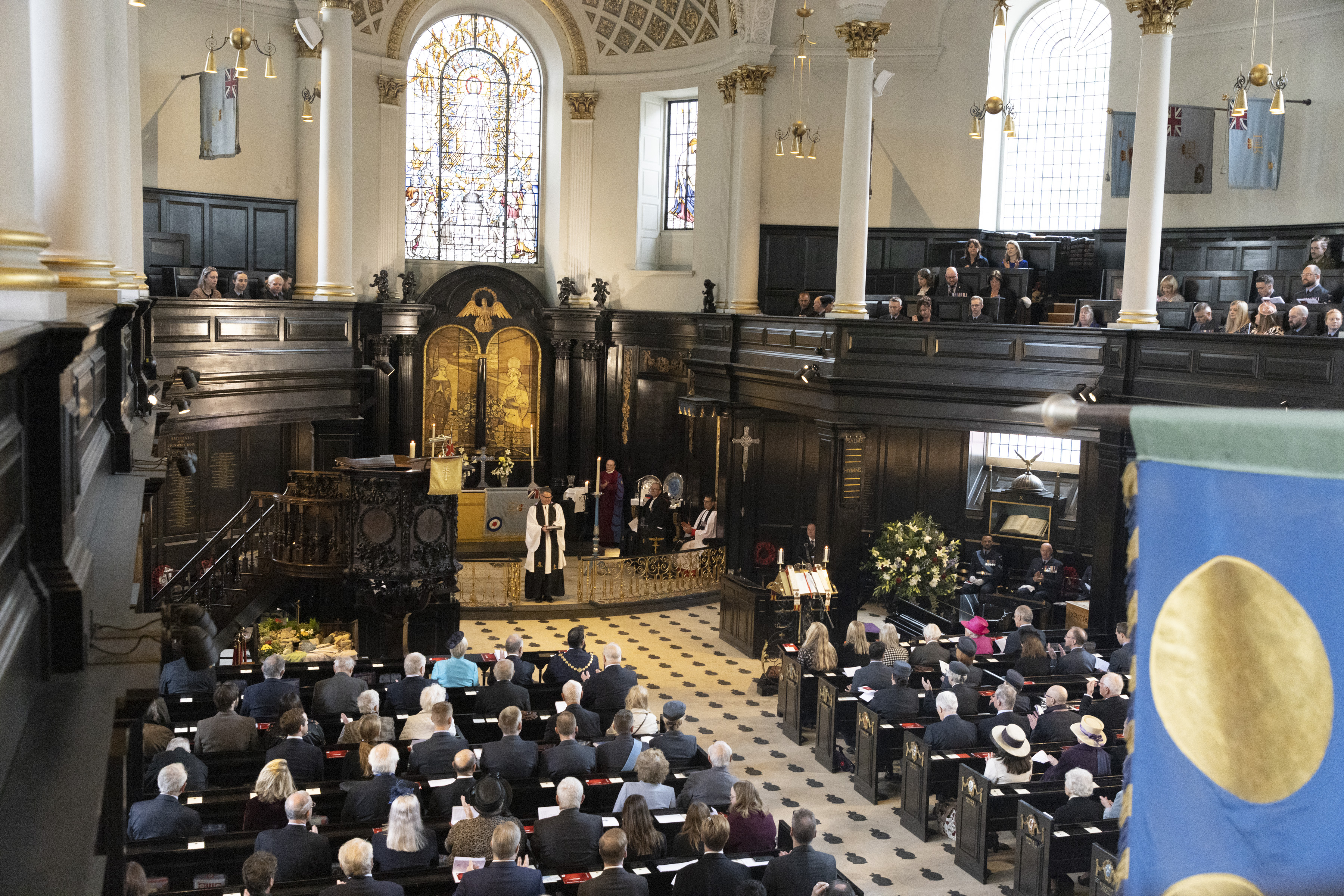 Image shows Reverend leading a service inside St Clements Danes Church.