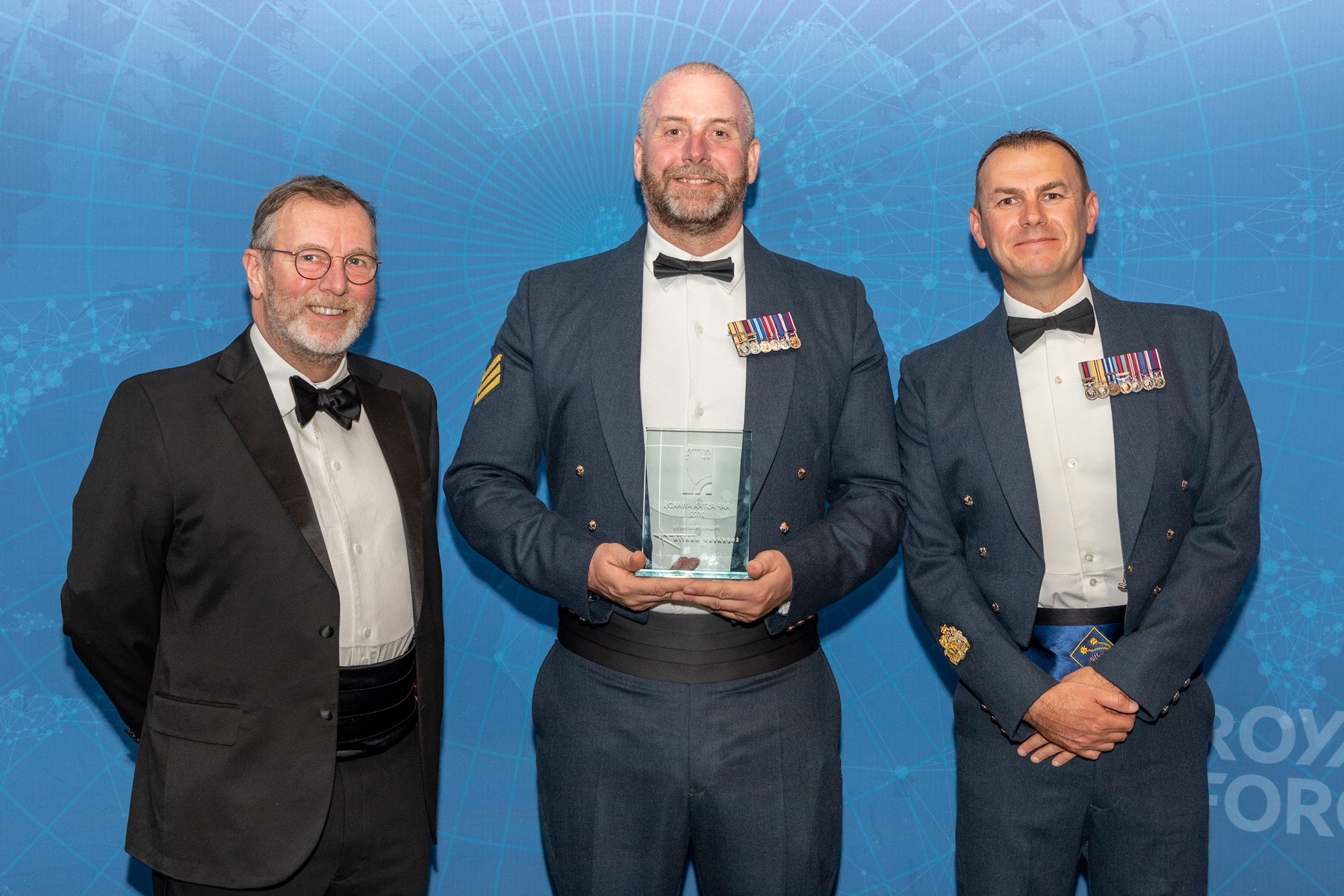 Image shows RAF aviator holding award for picture.
