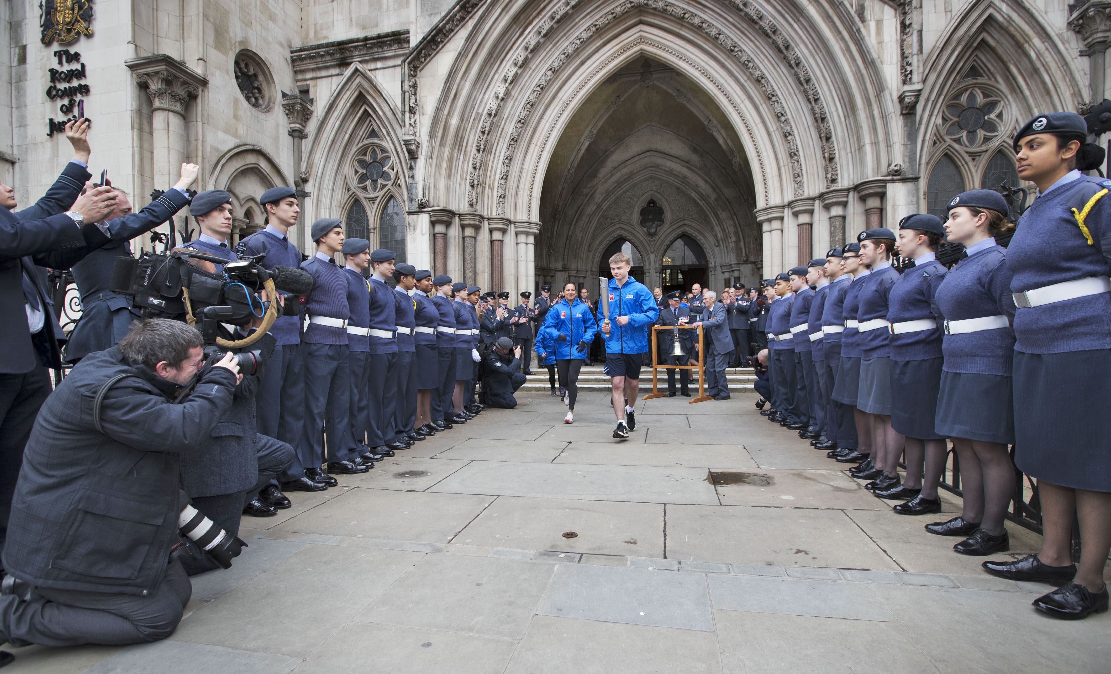 Image shows Air Cadets, aviators and a photography team watch the baton relay.