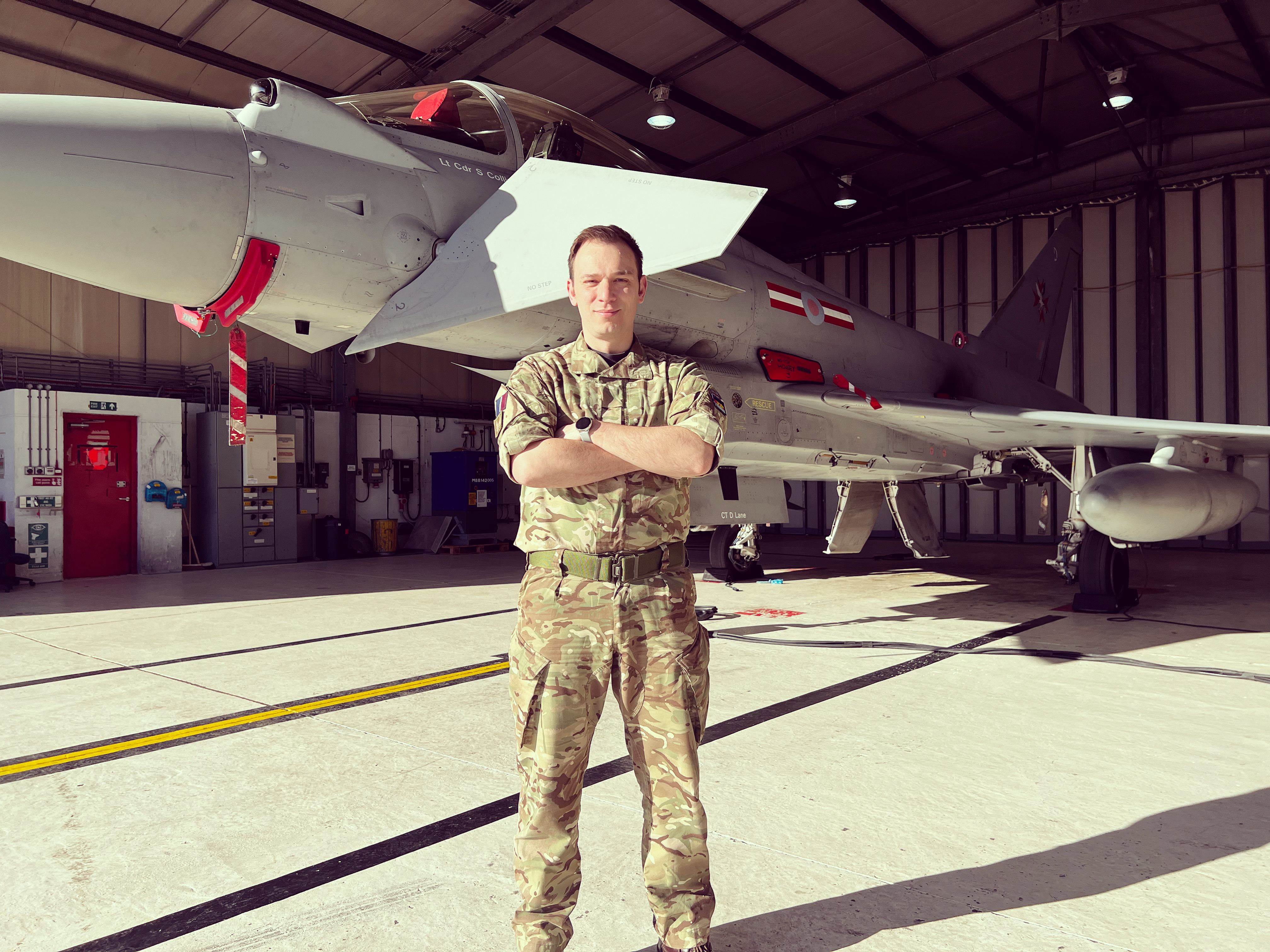 Image shows RAF aviator standing by a RAF Typhoon under the hangar.