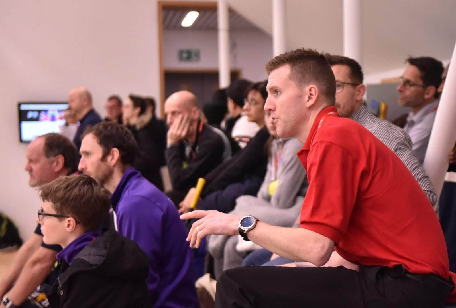 Image shows referee in the audience watching game.