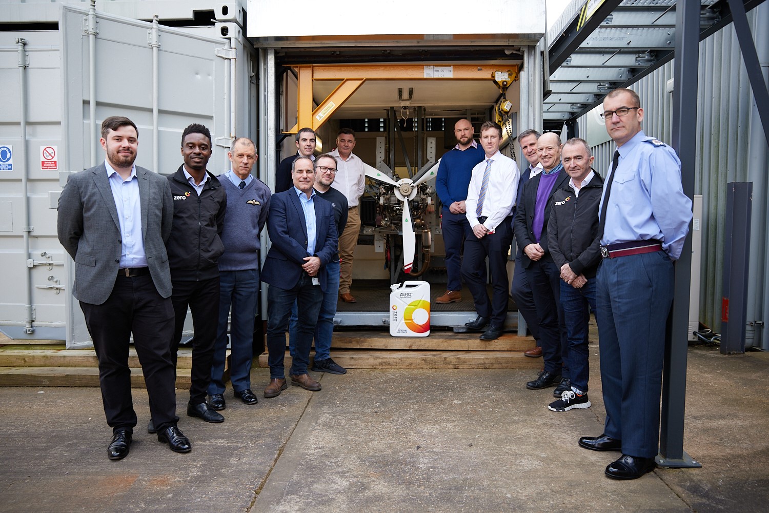 Image shows RAF personnel and civilians outside with the front rotator blades of aircraft.