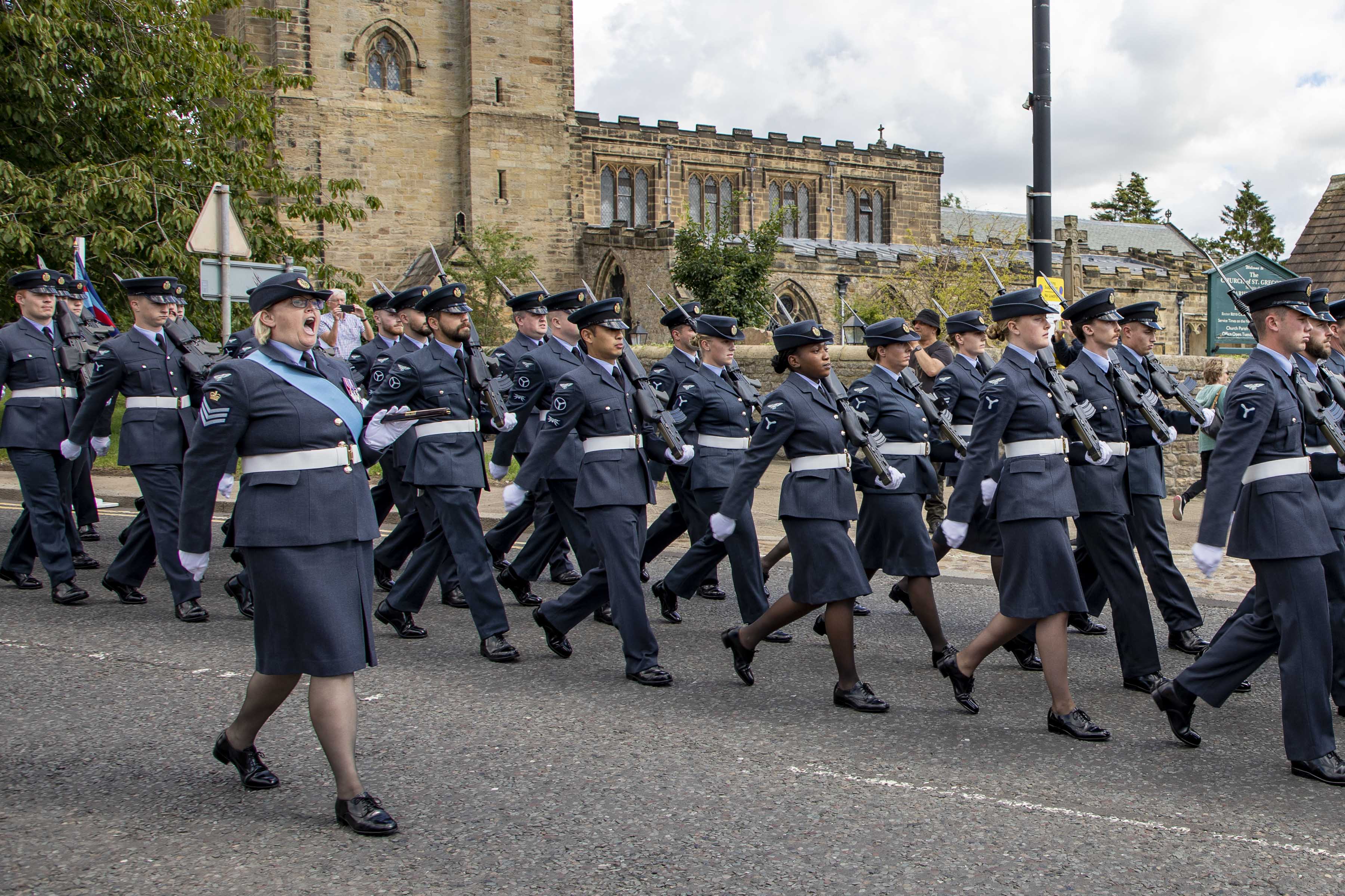 Image shows RAF aviators in parade with cathedral in the background.