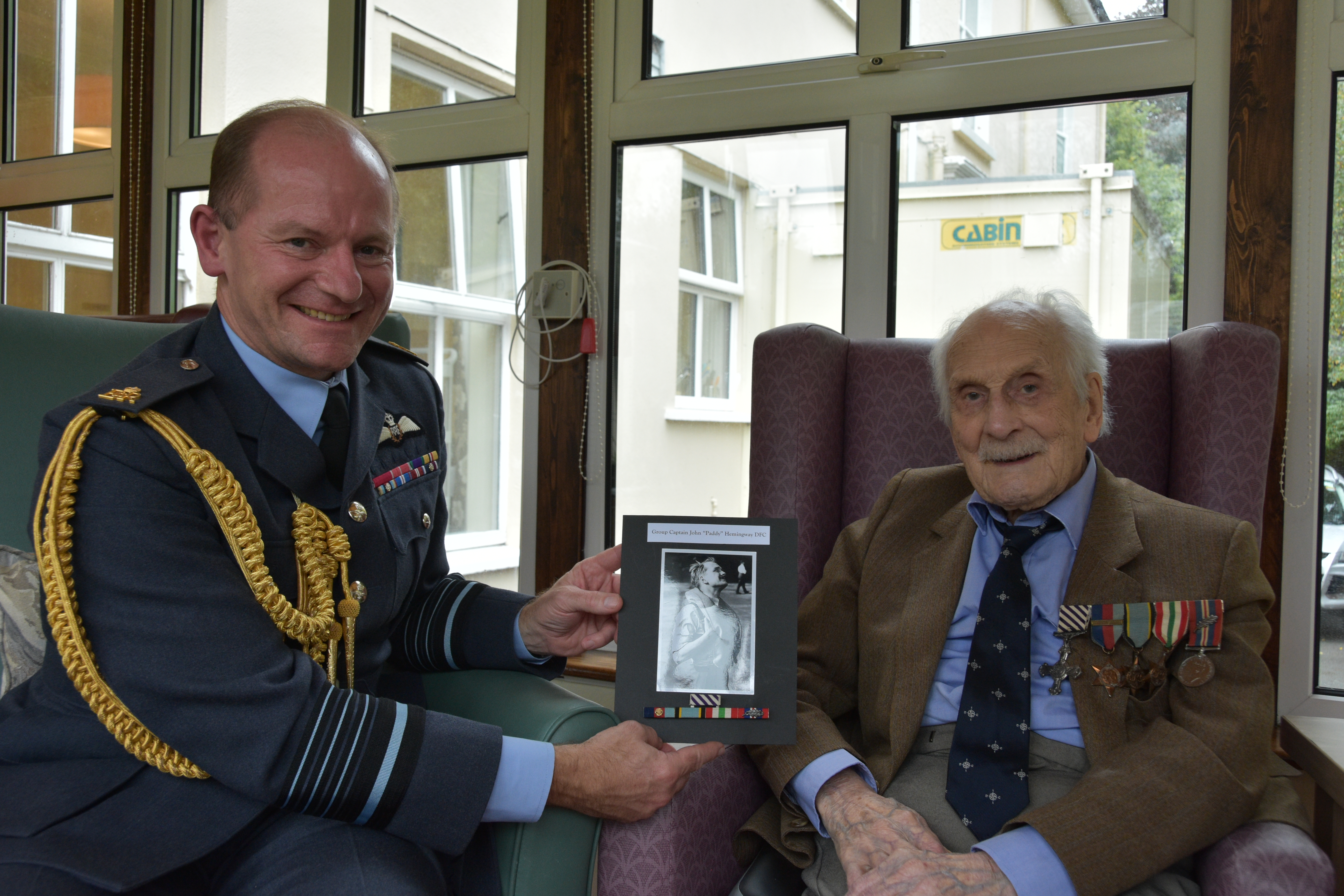 Group Captain (retired) John ‘Paddy’ Hemingway and Air Chief Marshal Sir Mike Wigston holding black and white picture.