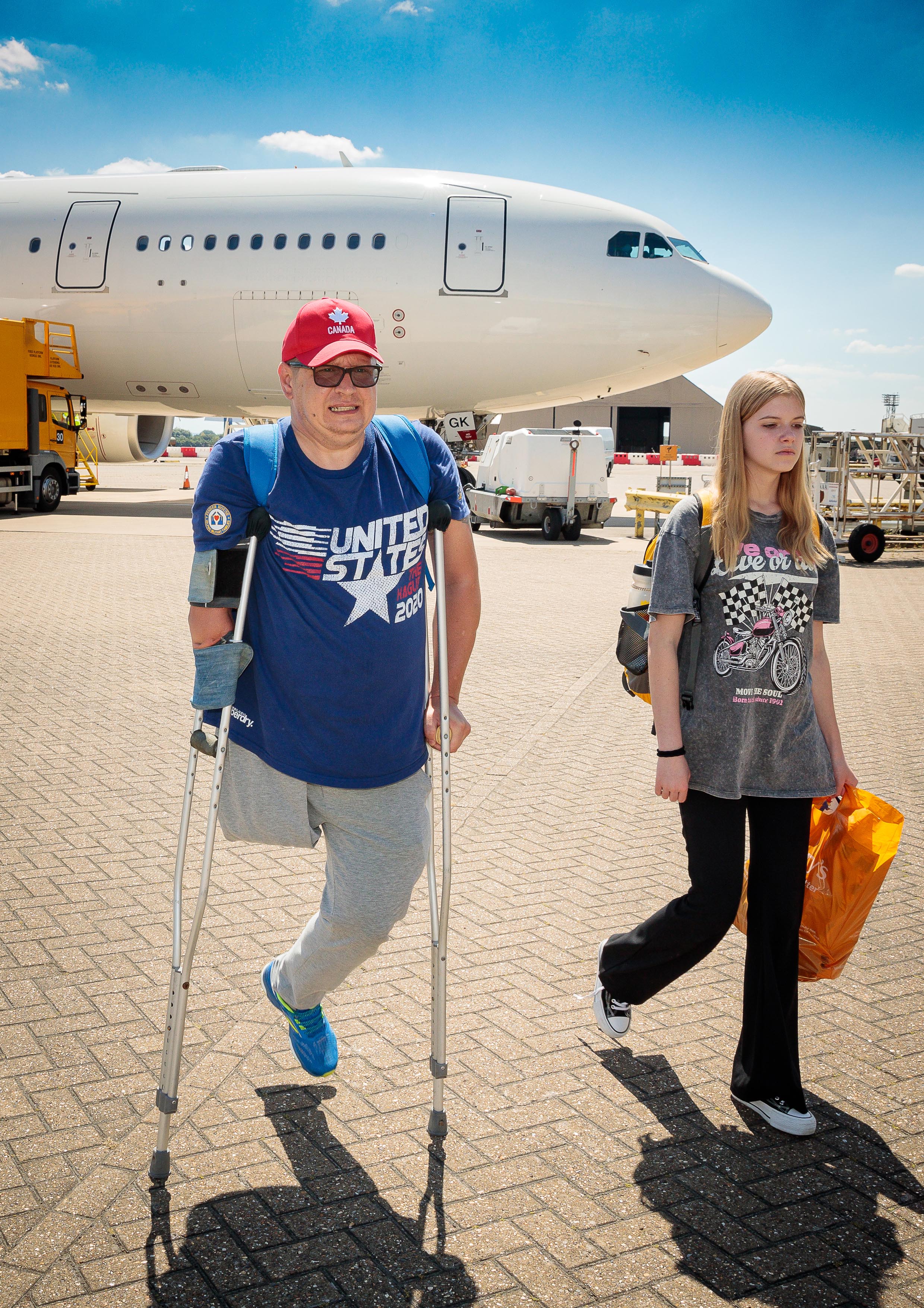 Image shows athlete with one leg on crutches and another on the airfield.