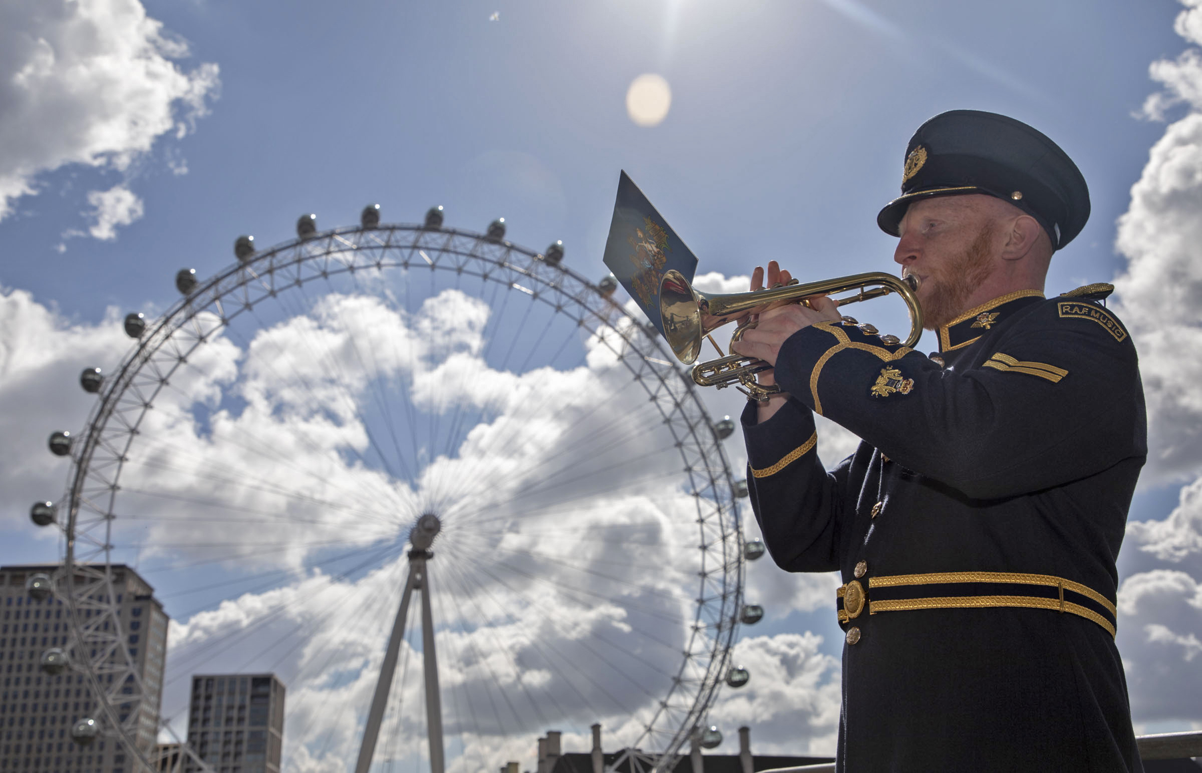 RAF Musician plays trumpet by London Eye.