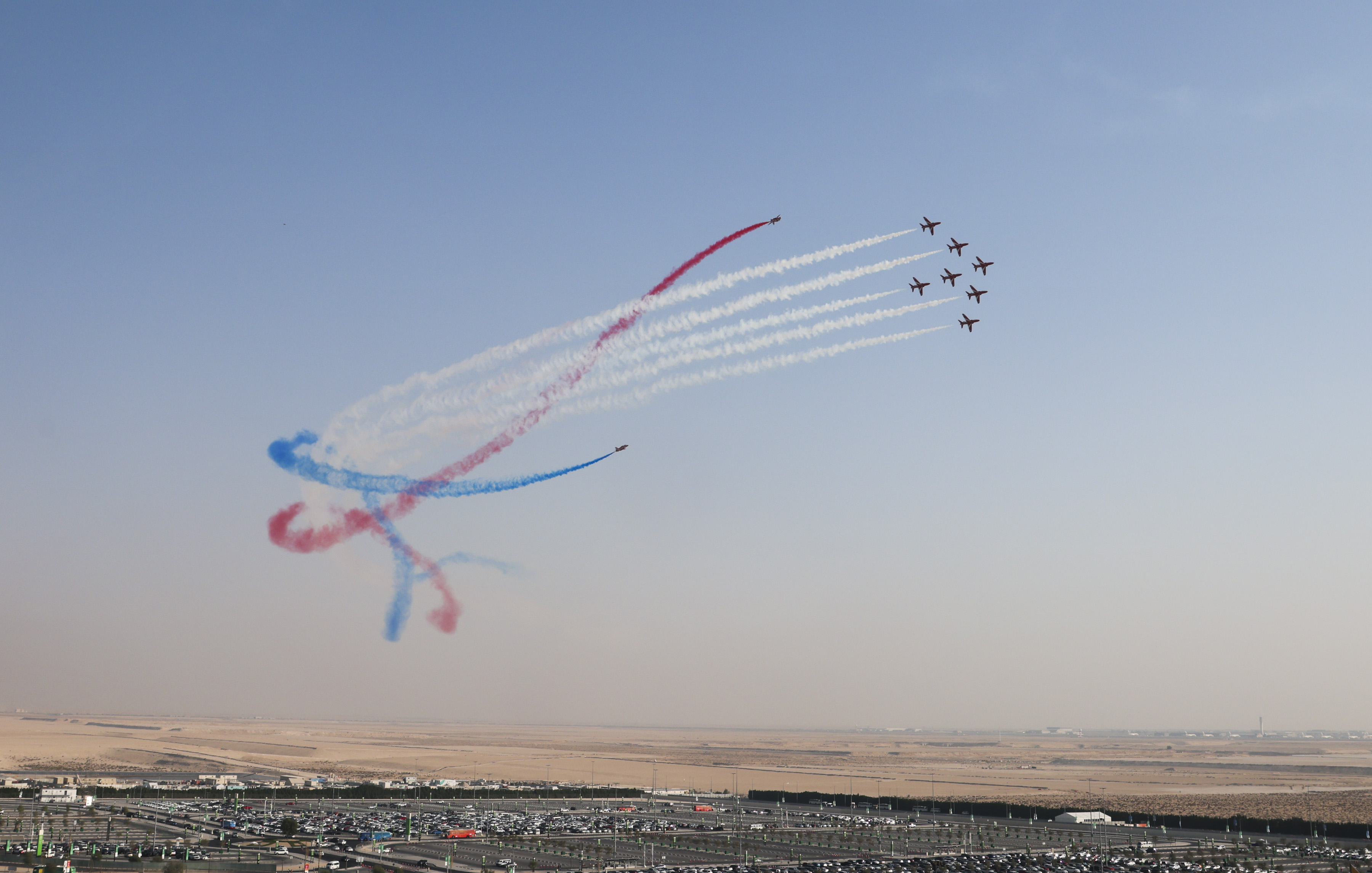 Red Arrows in formation with smoke tails in red, white, and blue.