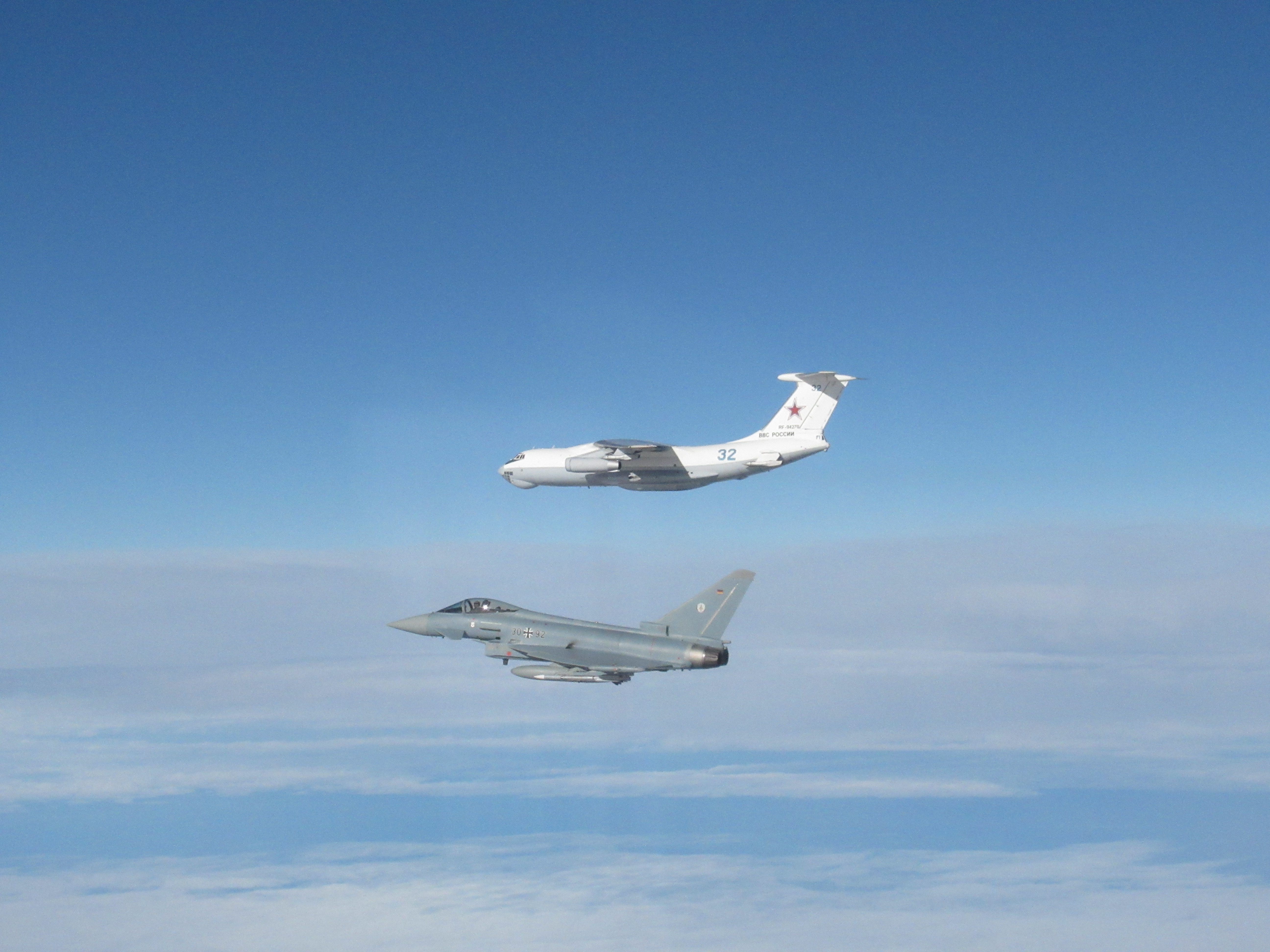 Images shows RAF Typhoon and Russian Ilyushin Il-78 Midas aircraft in flight above clouds.
