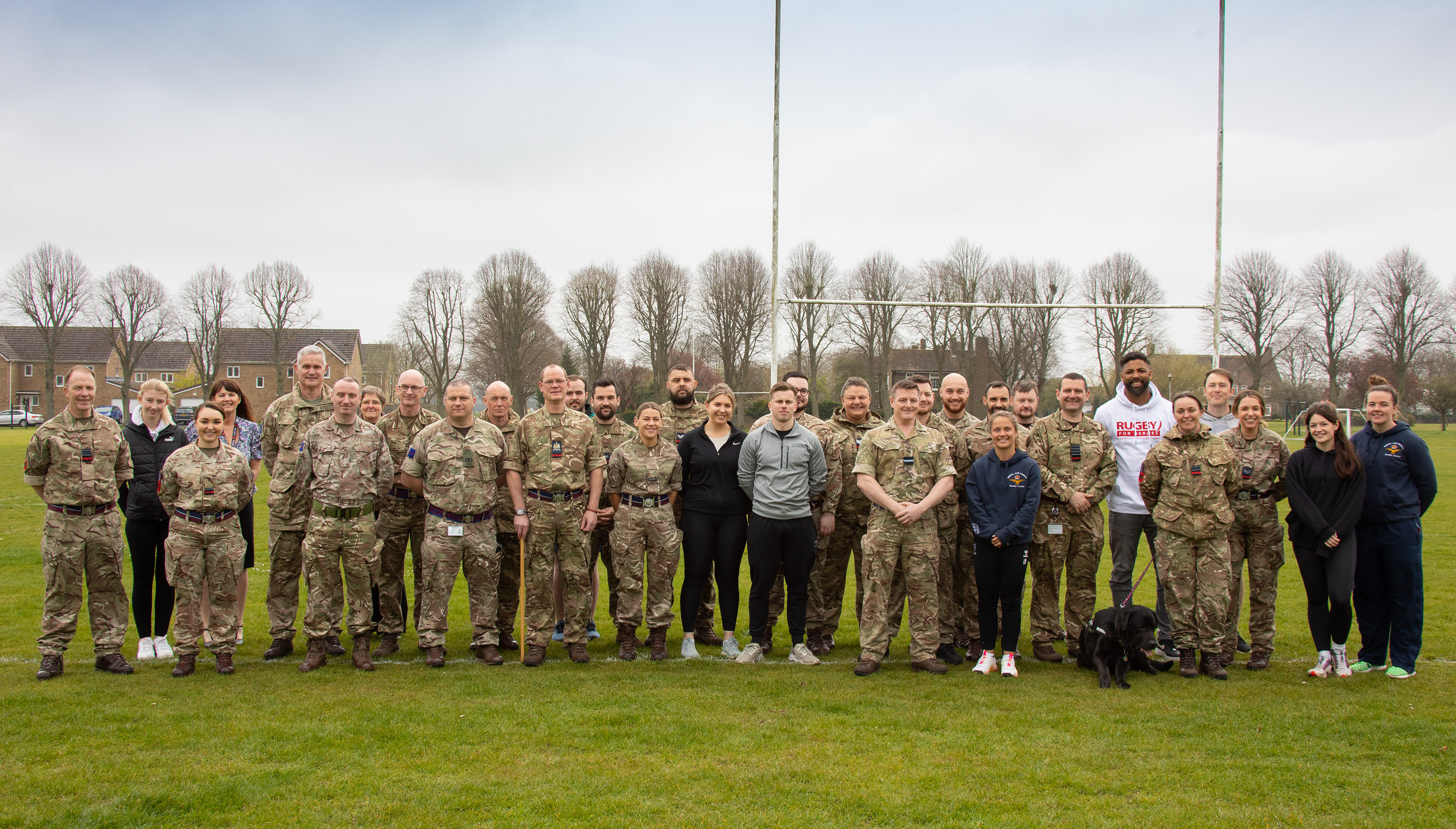 Personnel group photo on the rugby pitch.