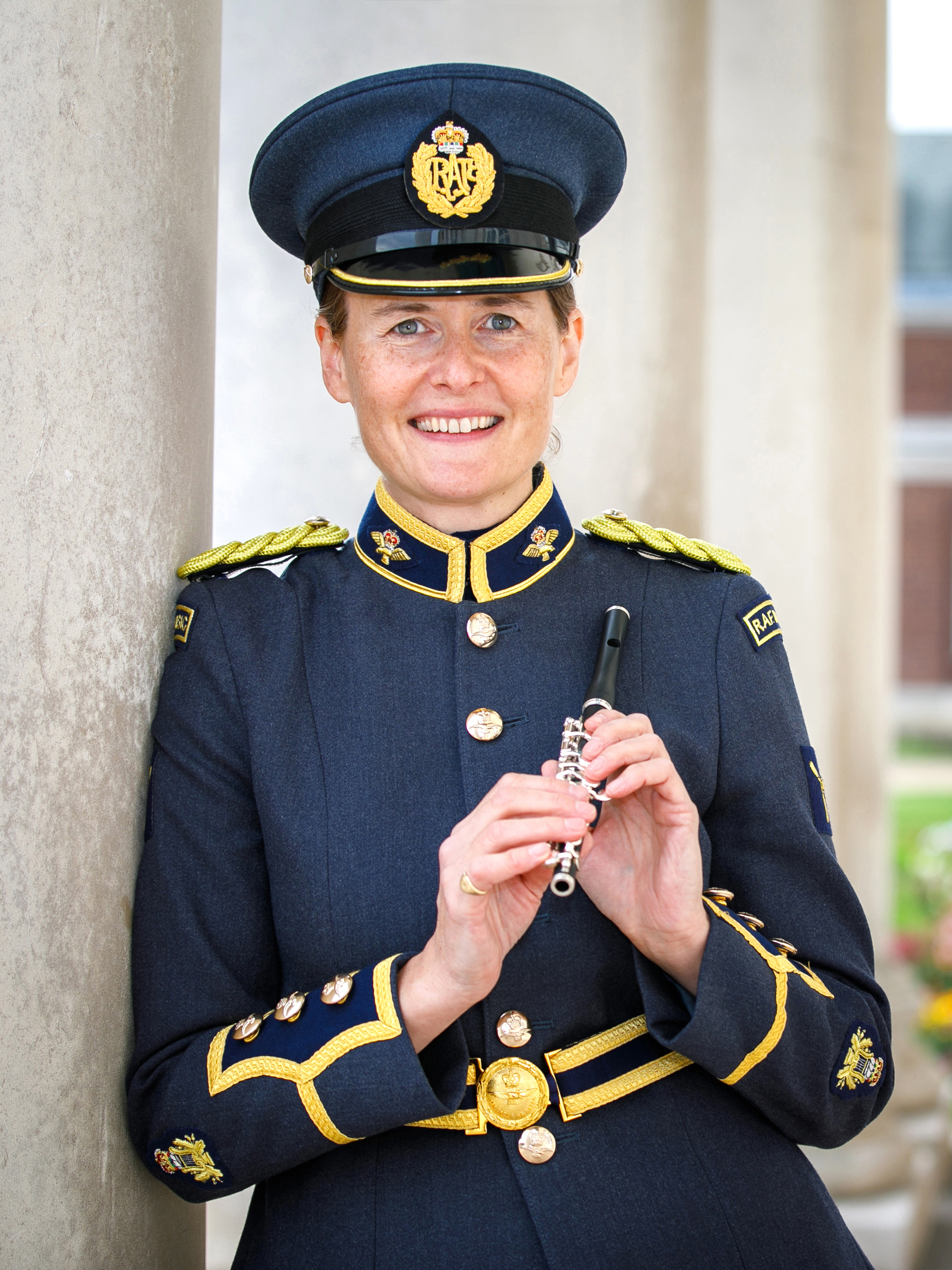 Ana holds wind instrument in uniform.
