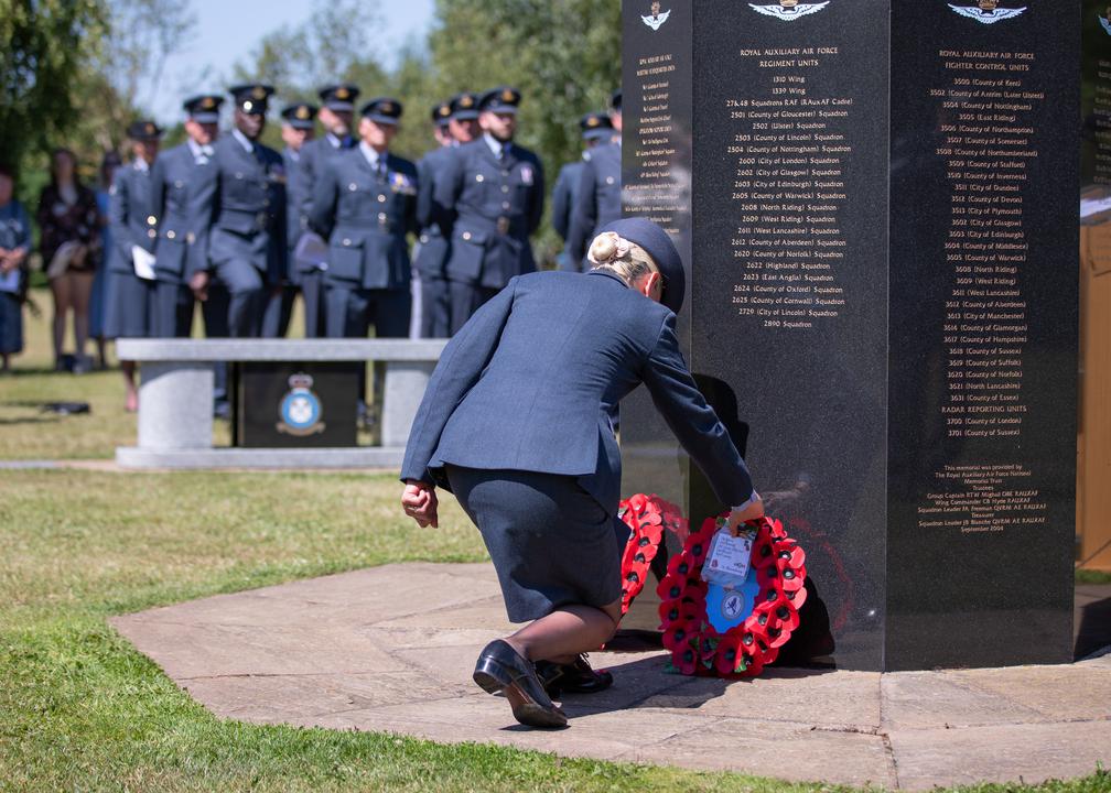 Aviator lays a poppy wreath on the memorial.