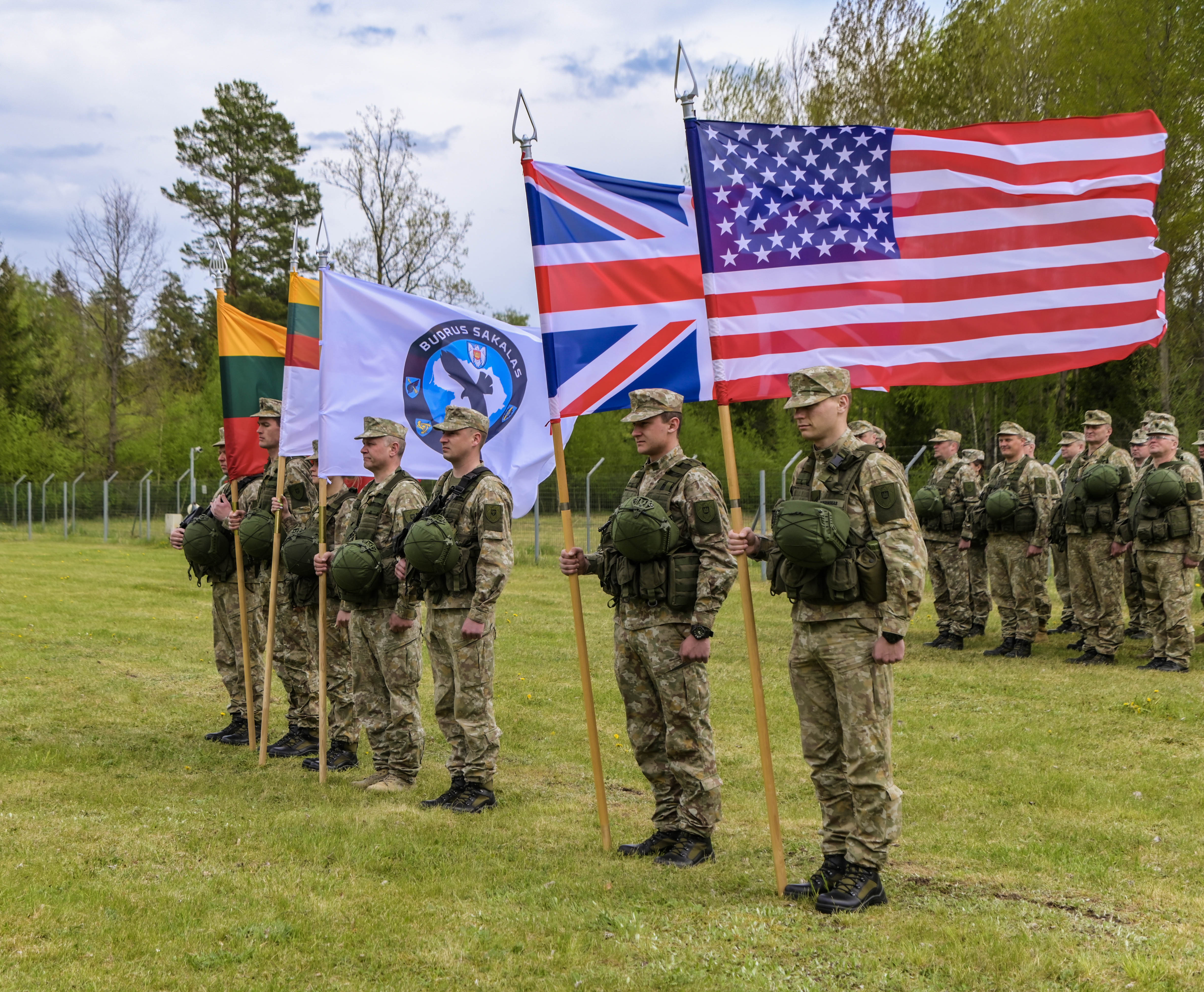 Personnel stand with country flags.