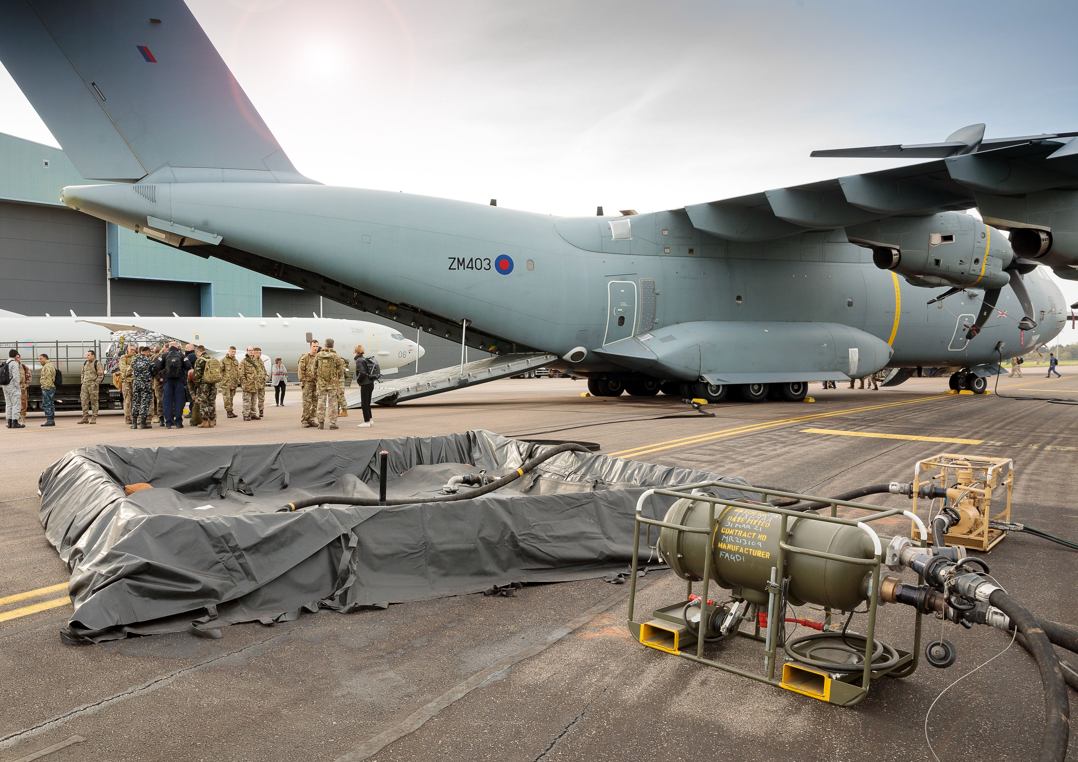 Image shows RAF Poseidon on the airfield with RAF aviators, refuelling tanks, and spills kit.