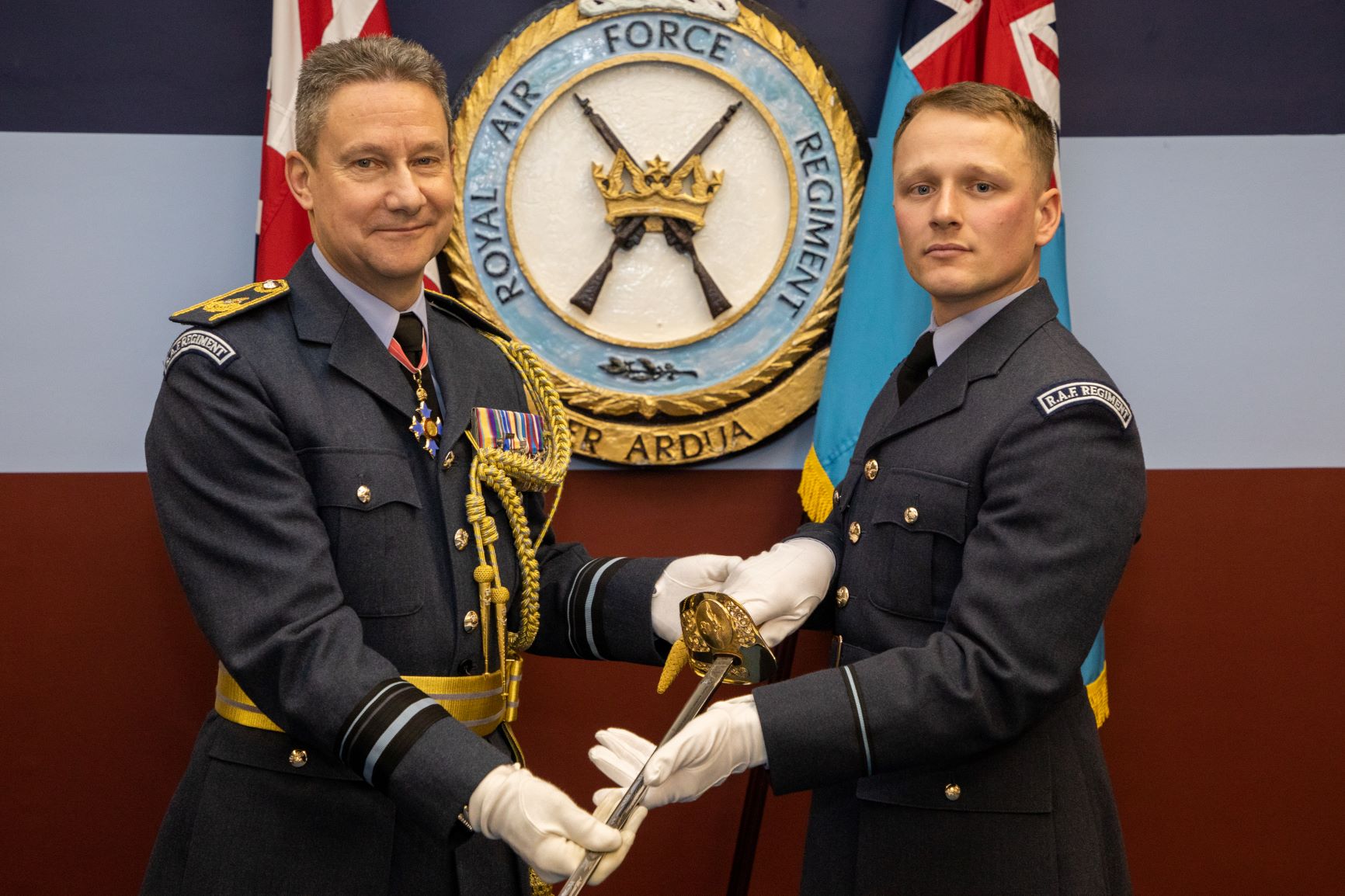 Image shows RAF aviators holding Officer's Sabre.