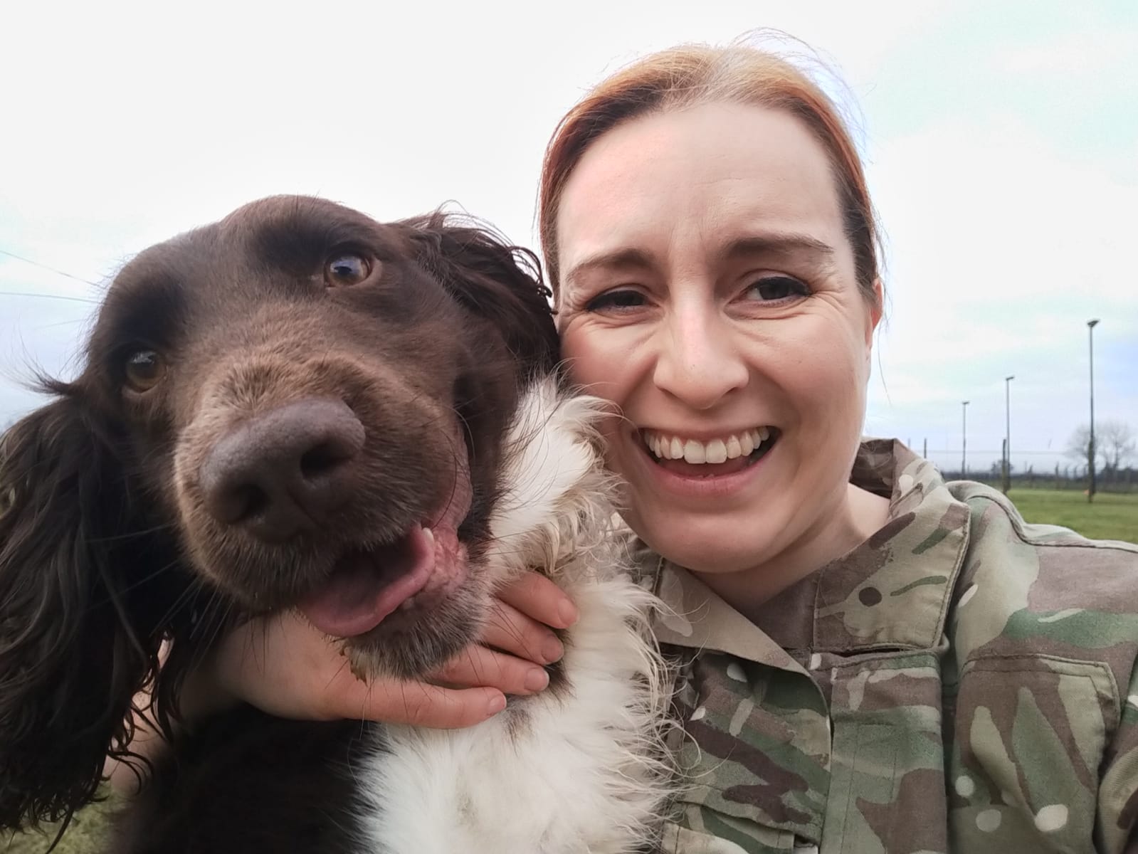 RAF Dog Handler holds her dog. 
