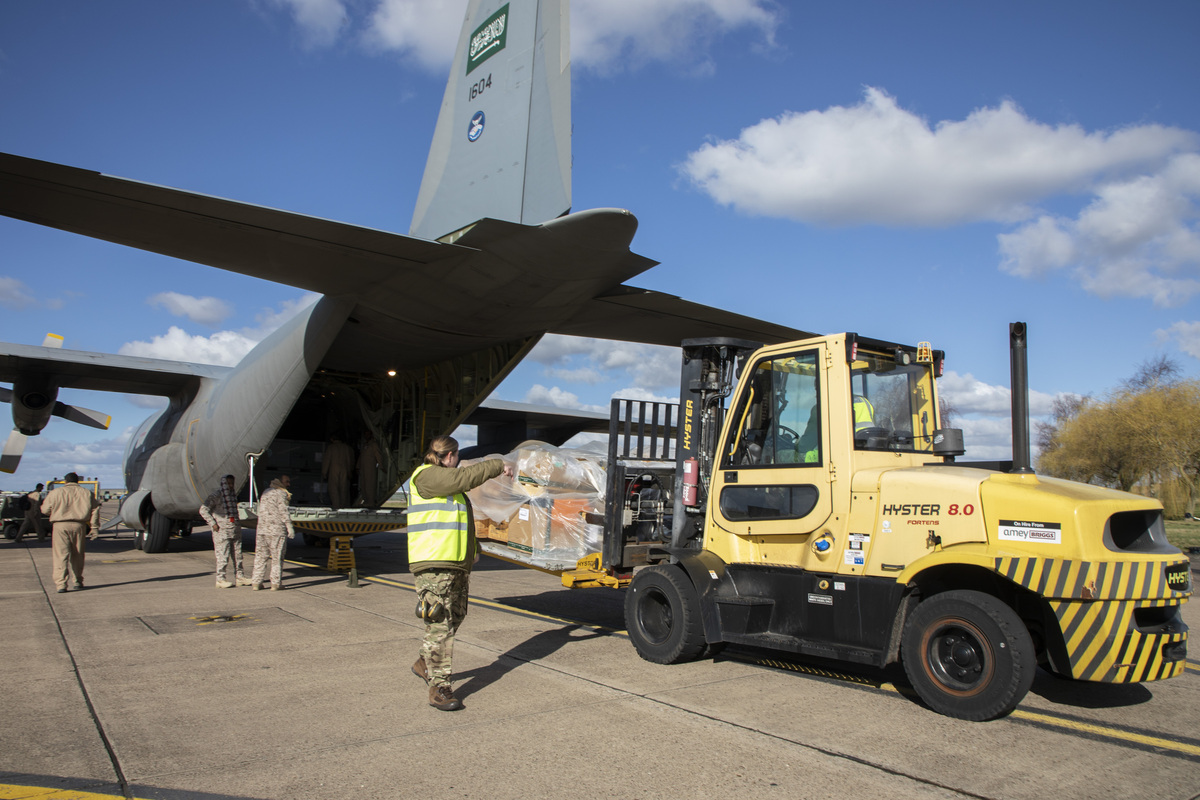 Image shows personnel on the airfield, with the RAF Voyager and cargo mover vehicle.