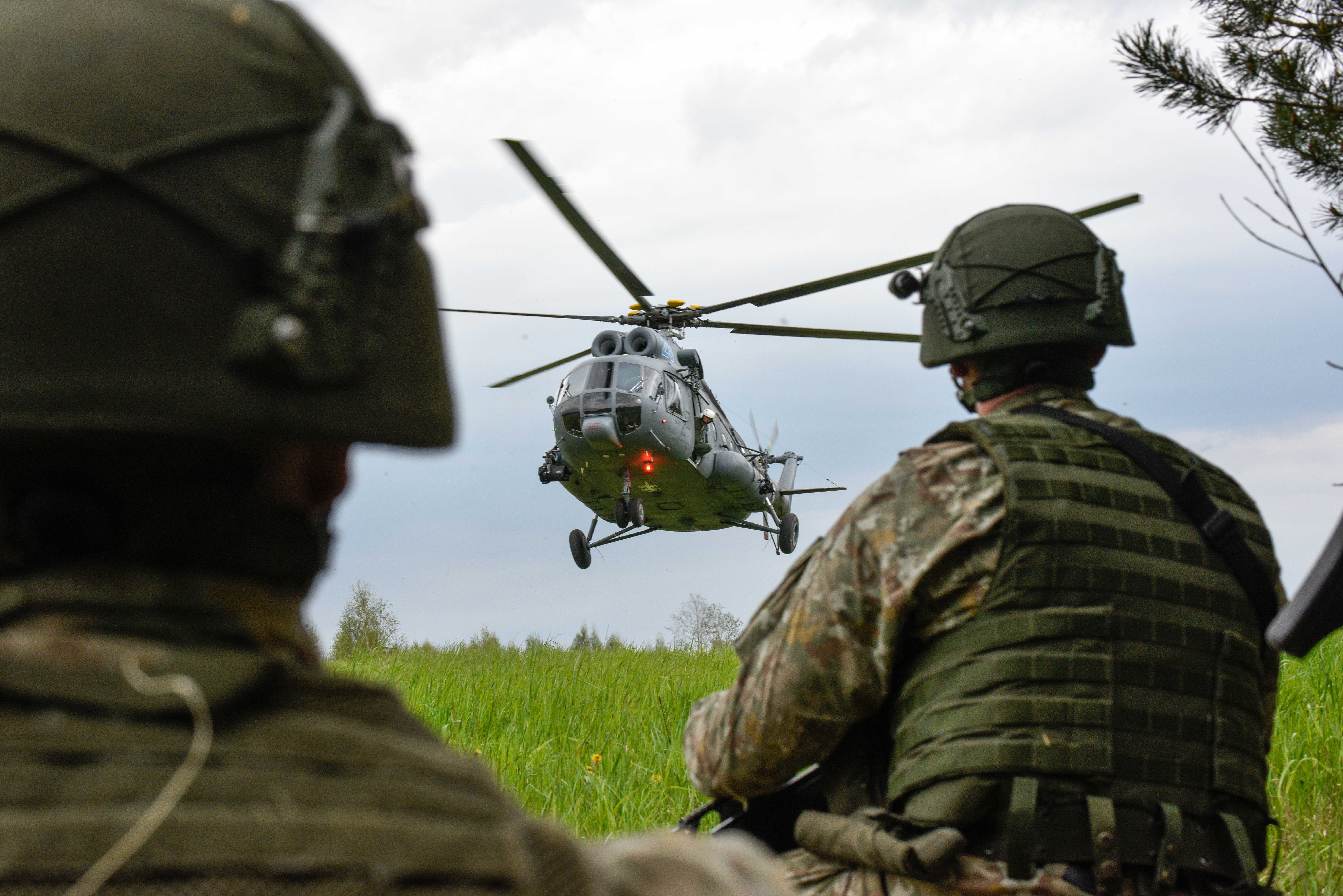 Personnel look towards helicopter landing on exercise.