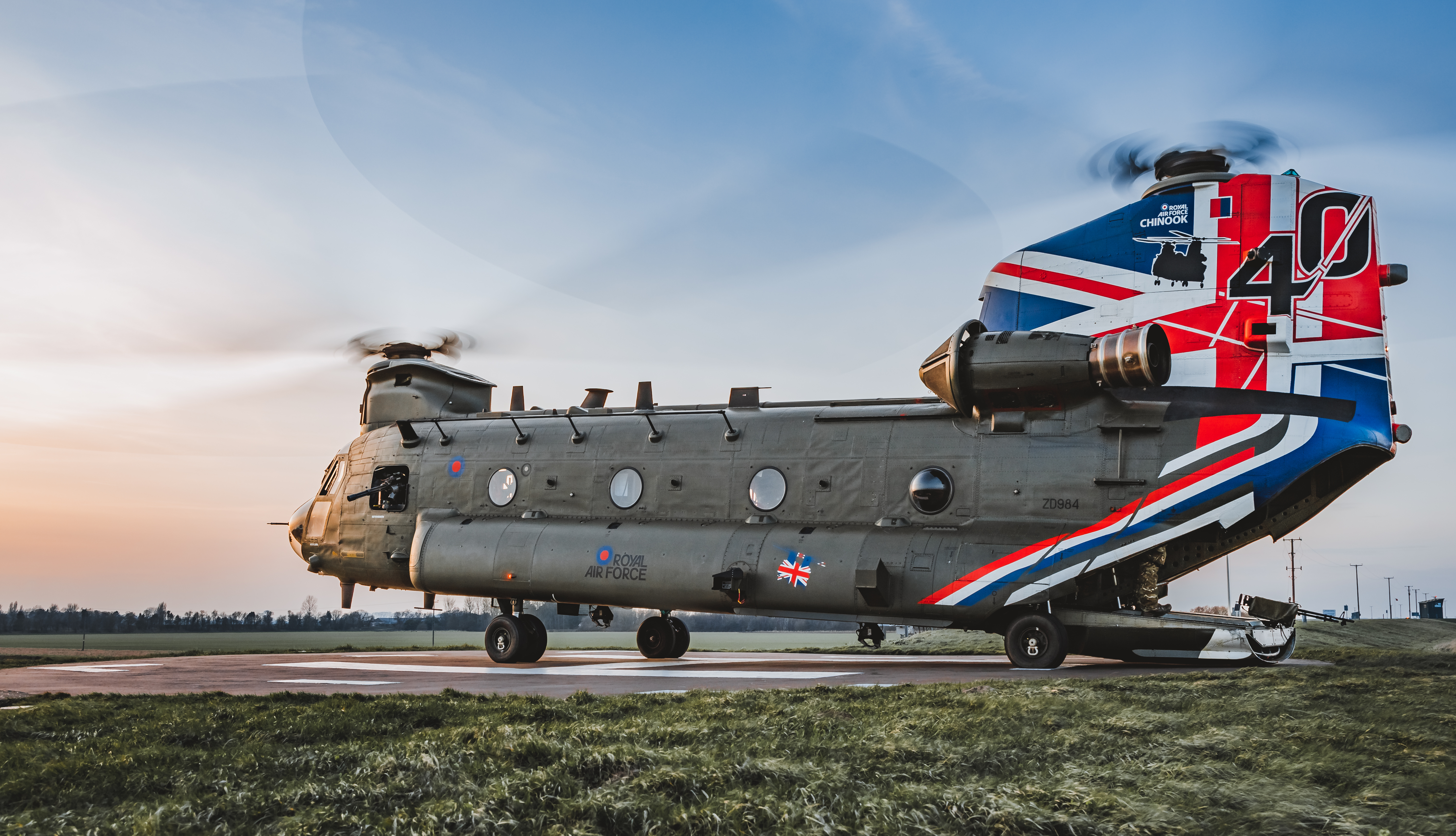 Image shows Chinook with Union Jack bodypaint on the airfield and its cargo bay open.