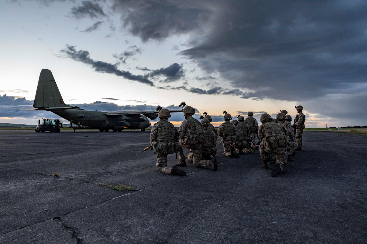 Image shows RAF Regiment kneeling in front of carrier aircraft