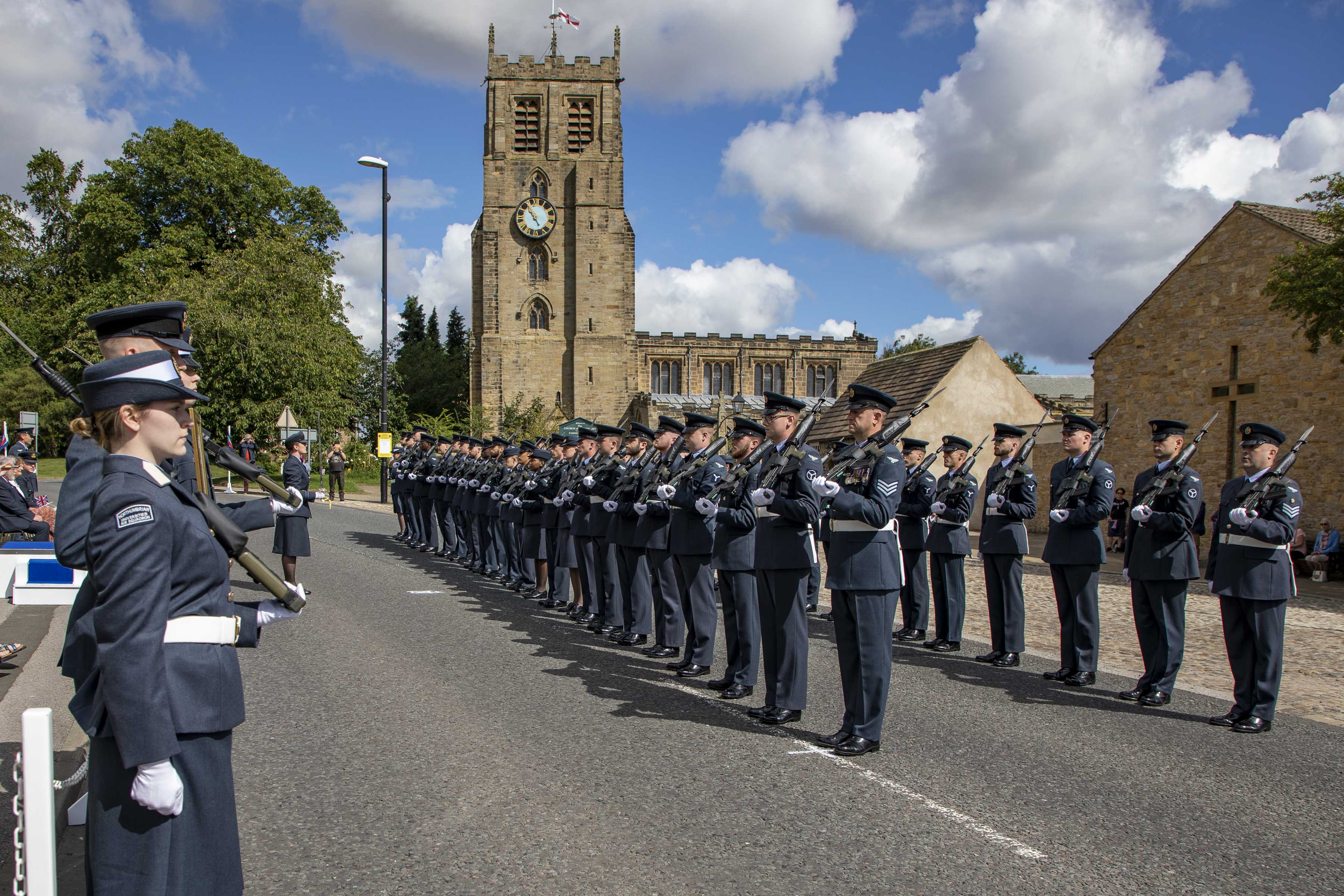 Image shows RAF aviators in parade with cathedral in the background.