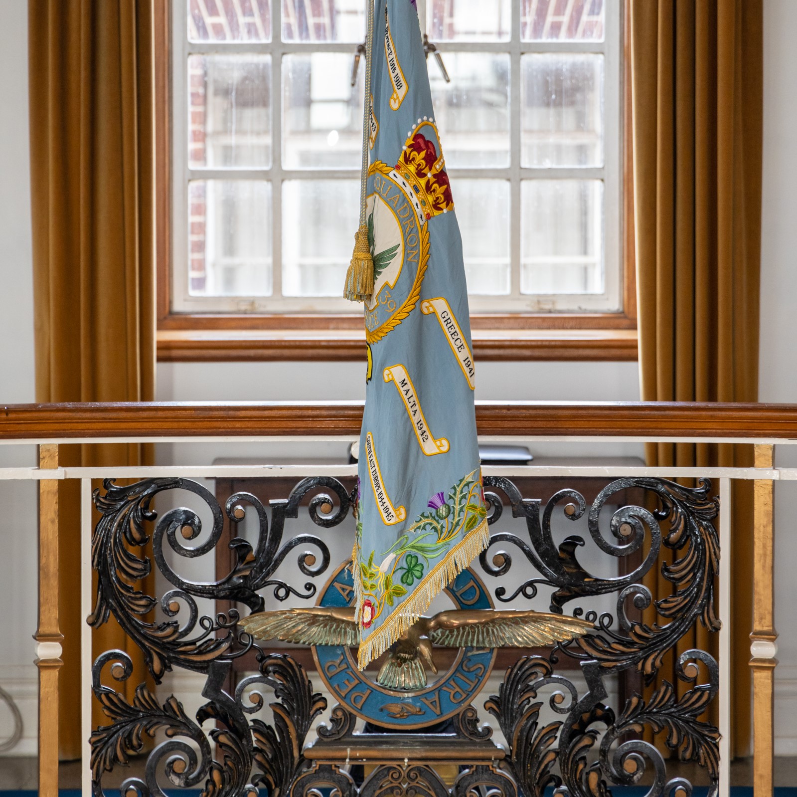 Image shows colour standard hanging from balcony inside Officers' Mess.