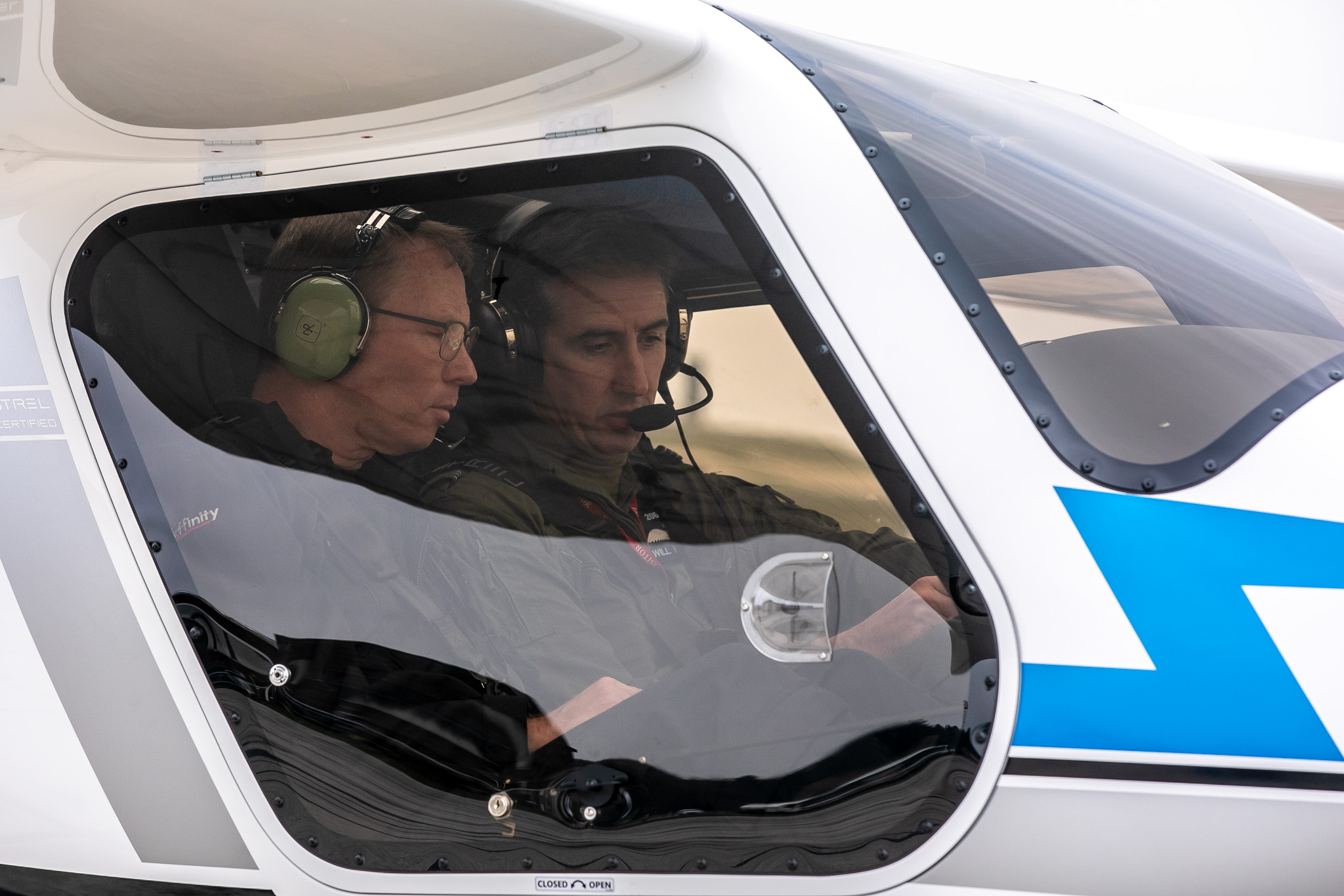 Pilots inside cockpit of electric aircraft.
